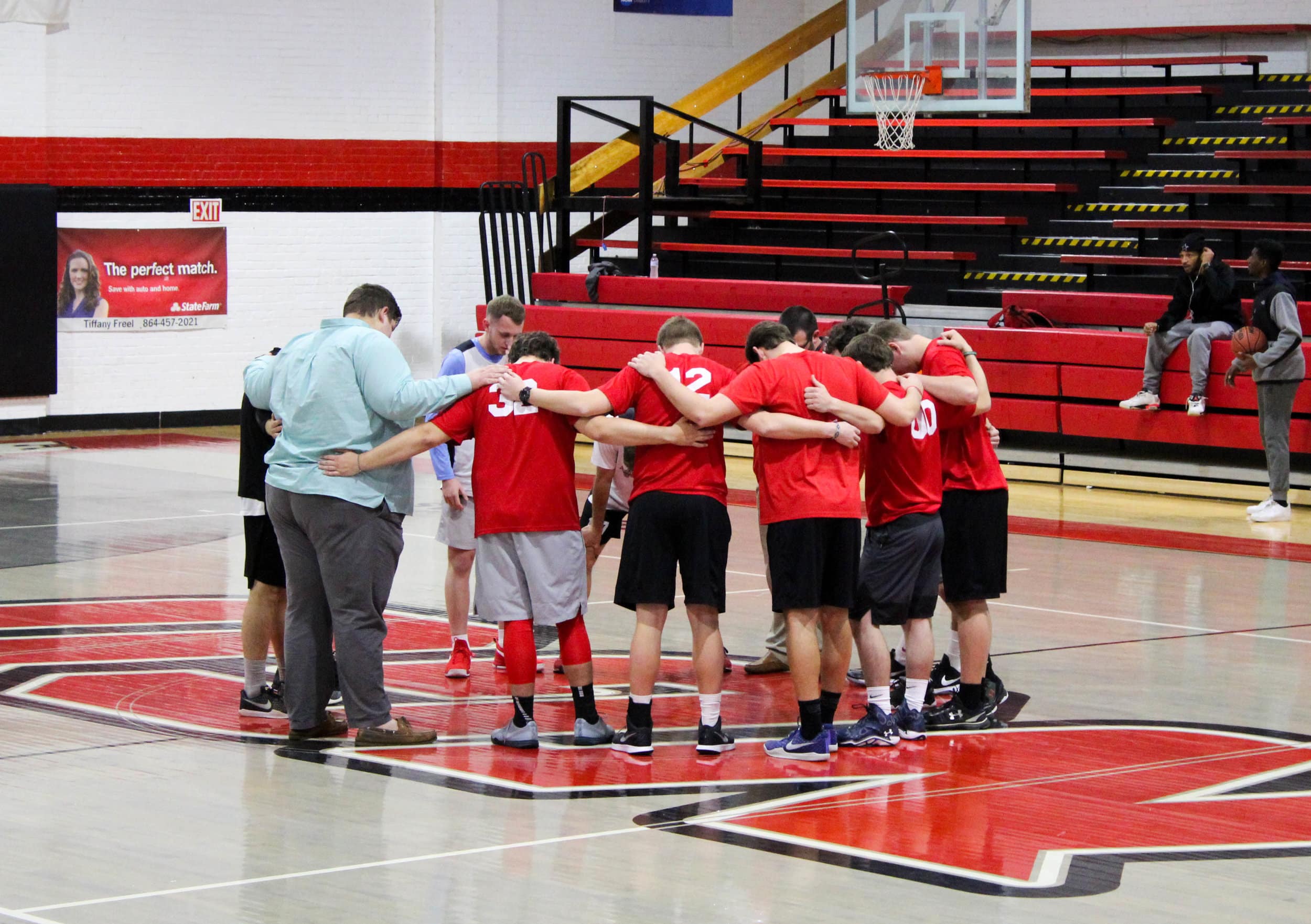 The two teams pray together at half court before the game begins.