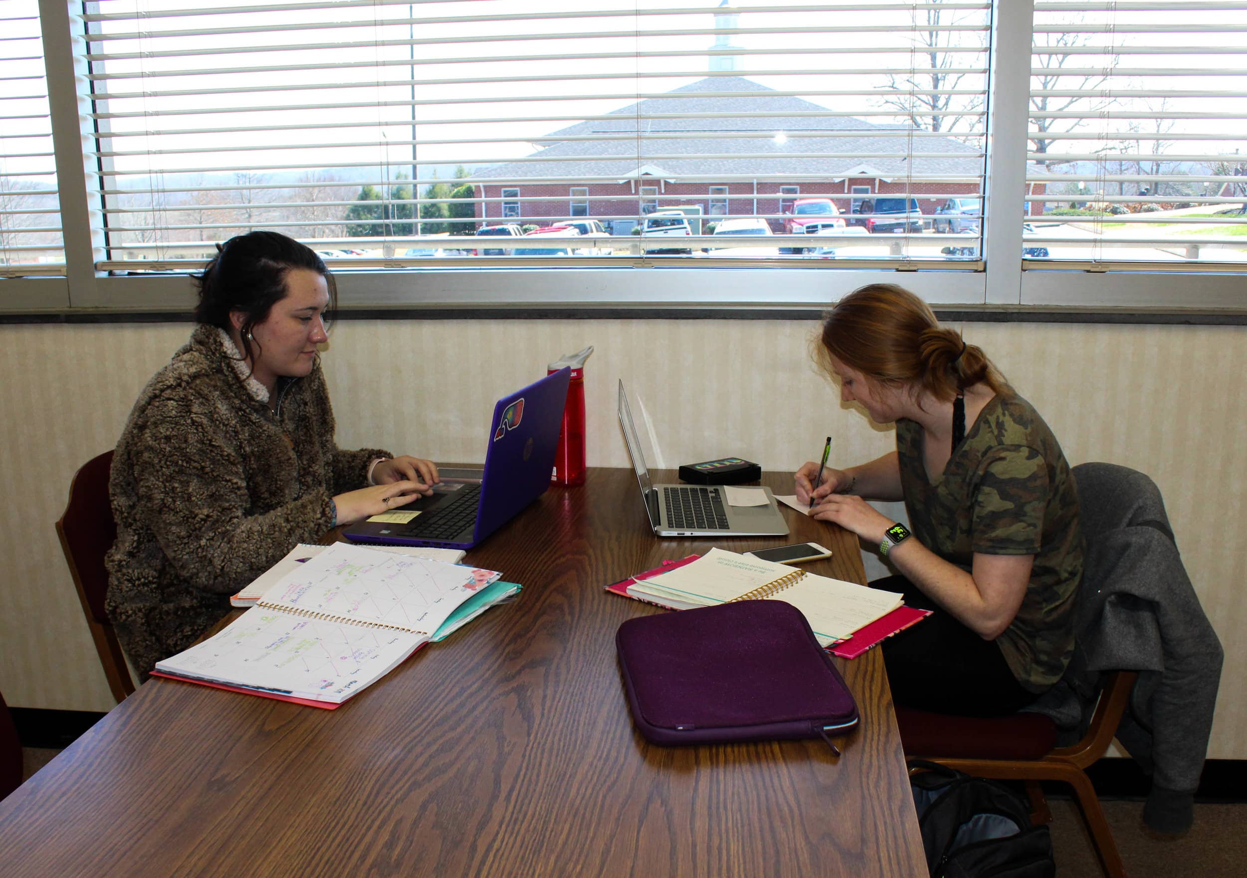 Freshman elementary education major Breanna Edwards and freshman sports management major Leah Elliot sit together in the library as they study various assignments.