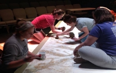 Scenic designer Tori Sheriff paints the set with theare practicum students.&nbsp;Source: DeAndra Watkins