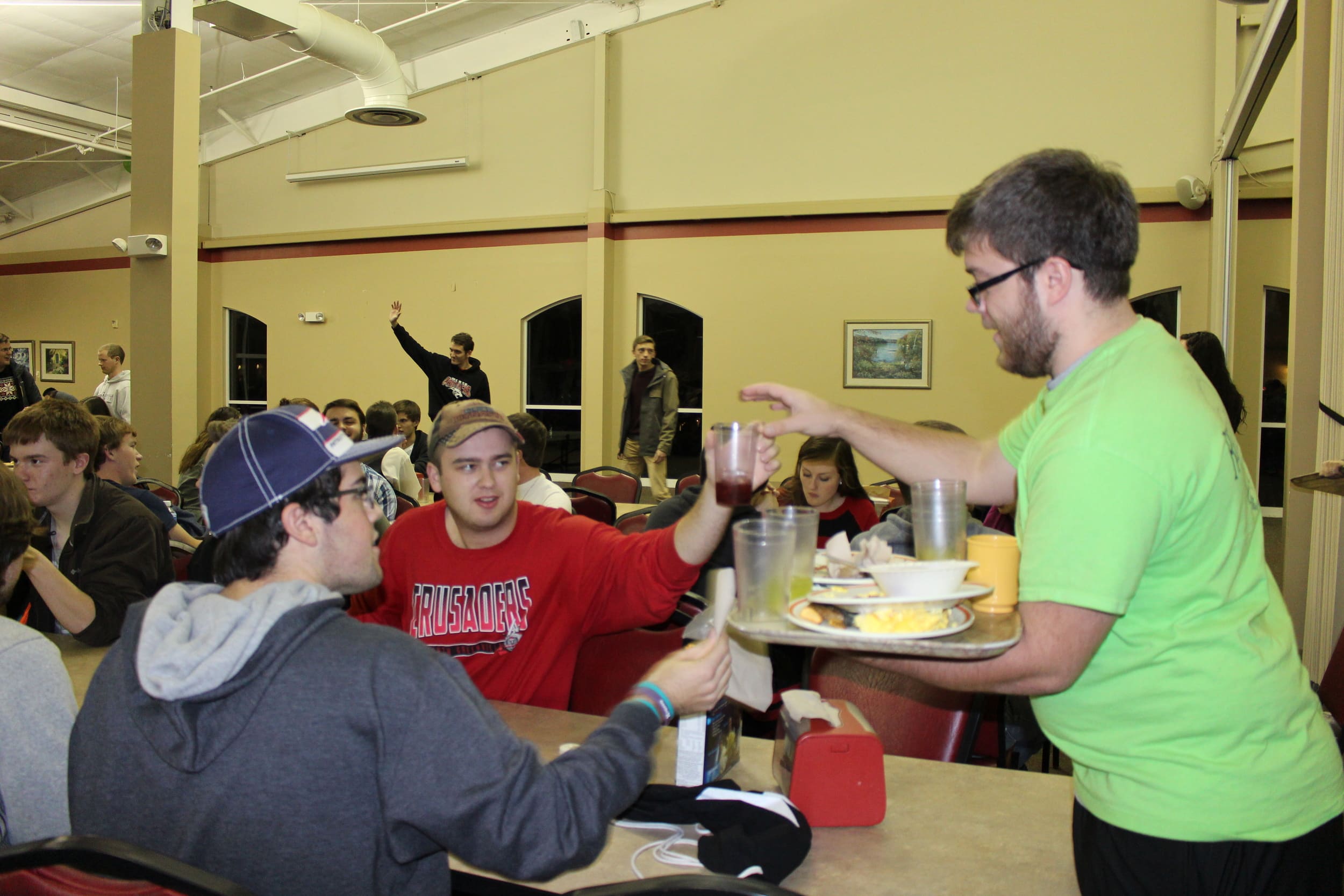 Jeremy Schultz, a Resident Assistant, takes students' dirty dishes during the late night breakfast on Thursday.