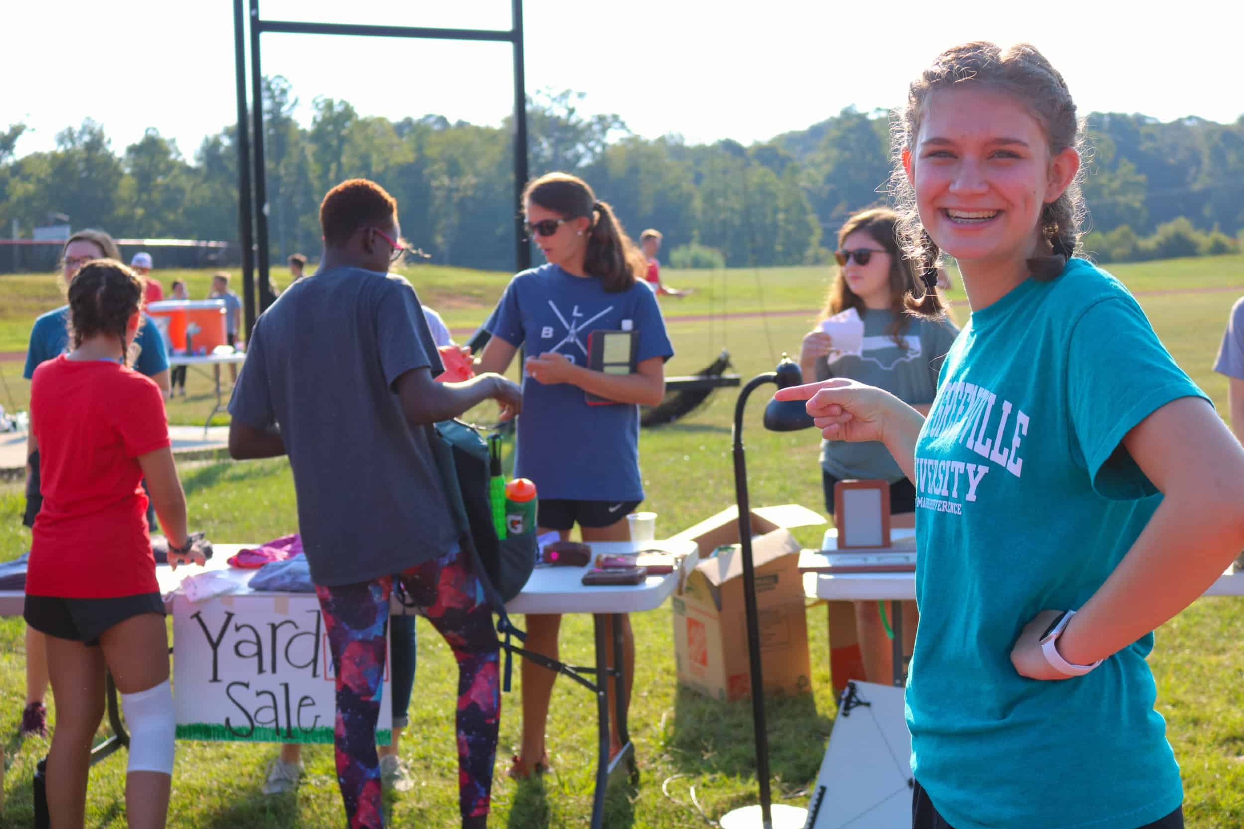 Lauren Bell, freshman, helps with the yard sale table during and after the race. People could bring their items to the track to add to the yard sale.