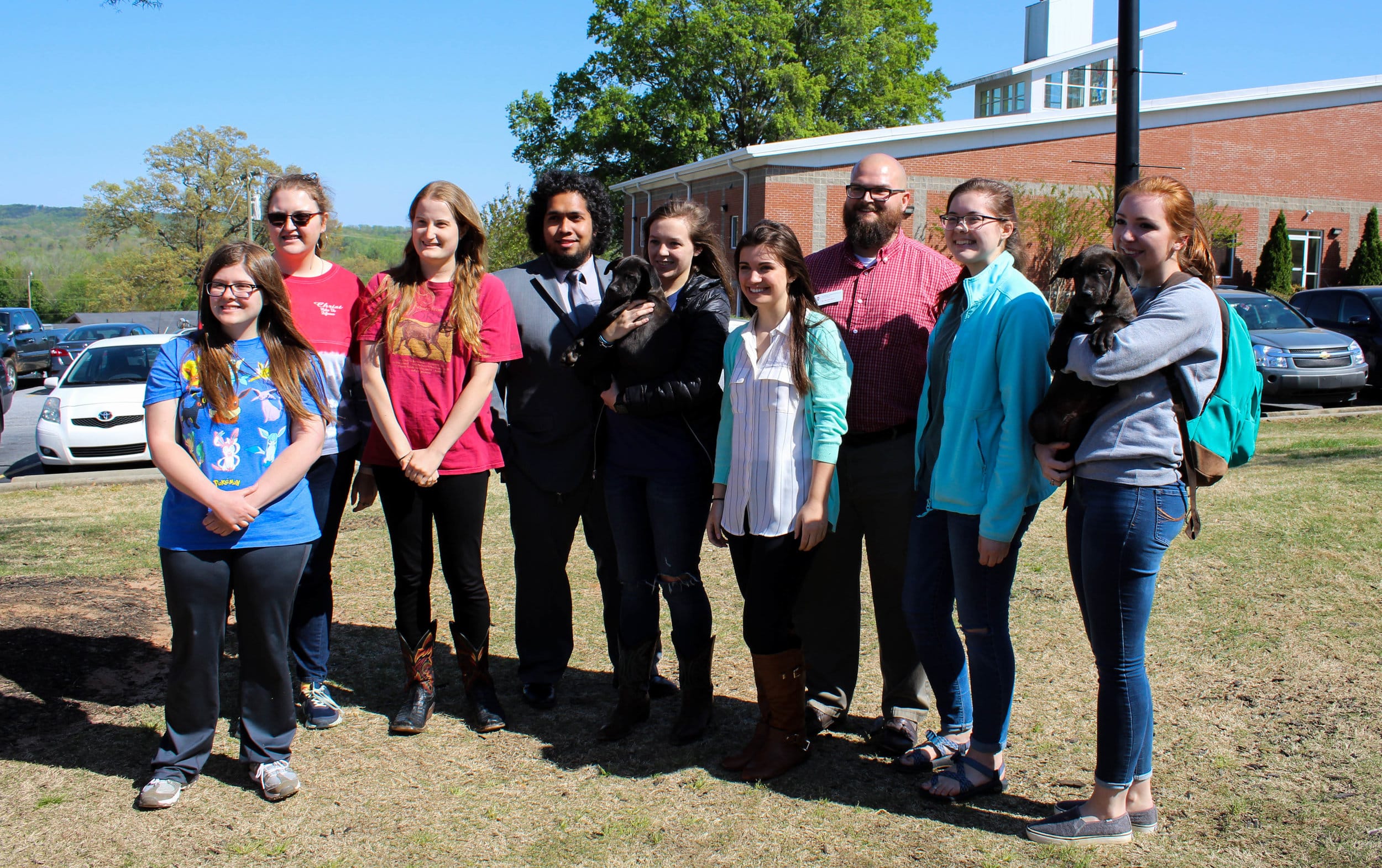 The Animal Science Club, who hosted the event, get together with some puppies to take a picture.