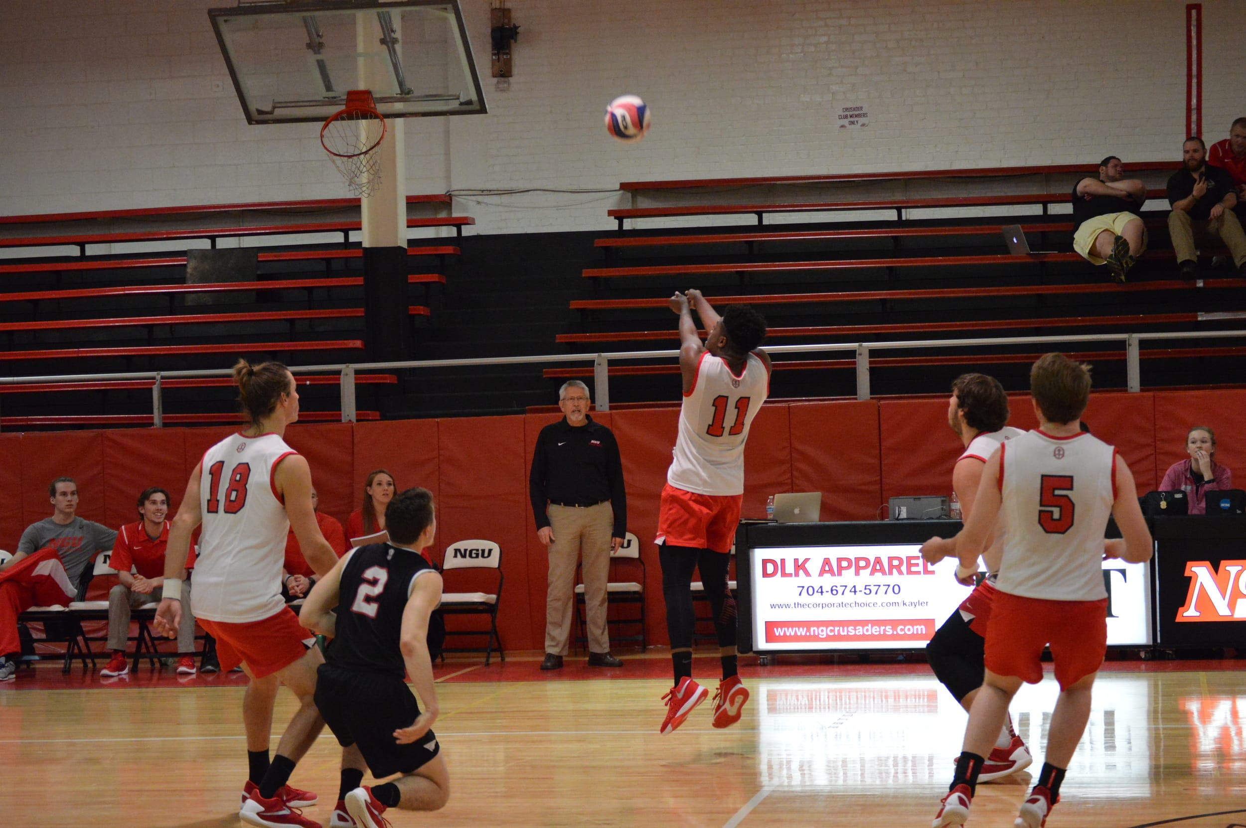 Caleb Arelus keeps the ball up and off the court floor on the Crusader's side.