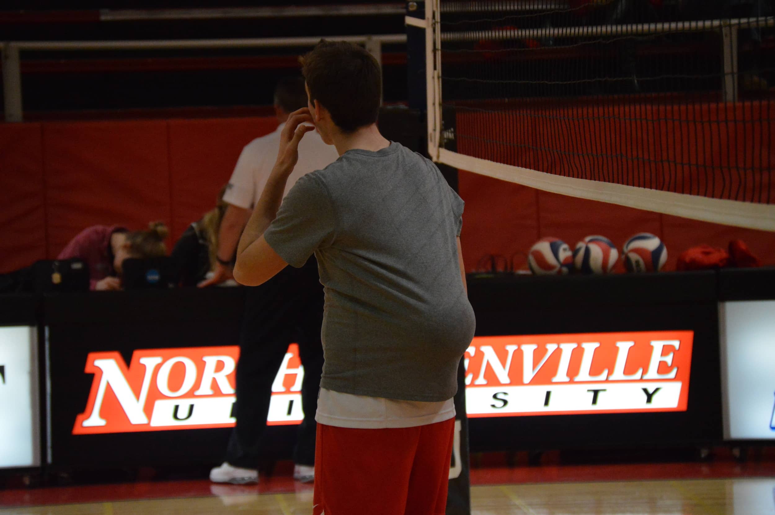 Putting a volleyball in his shirt, Grayson Lawrence has a little fun on the court.