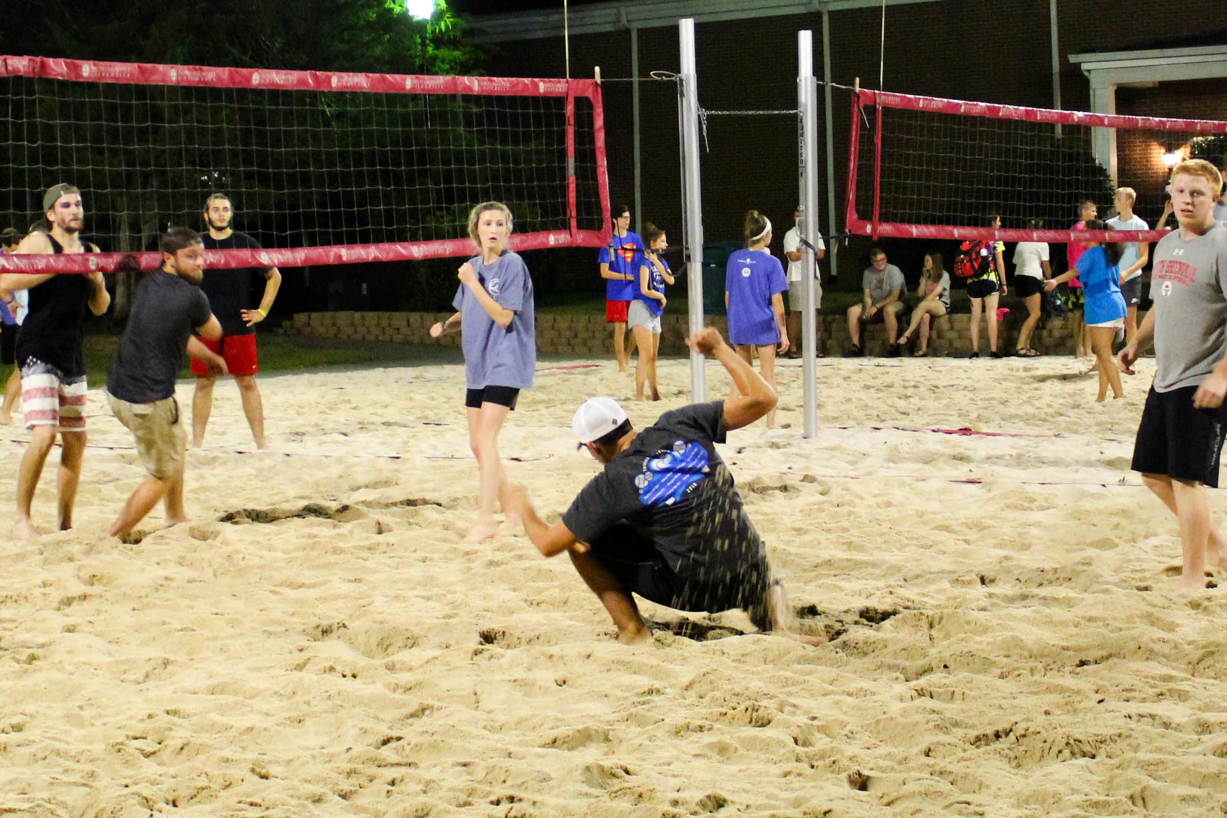 After the ball was spiked over the net, a player ducks to avoid being hit by the incoming ball.