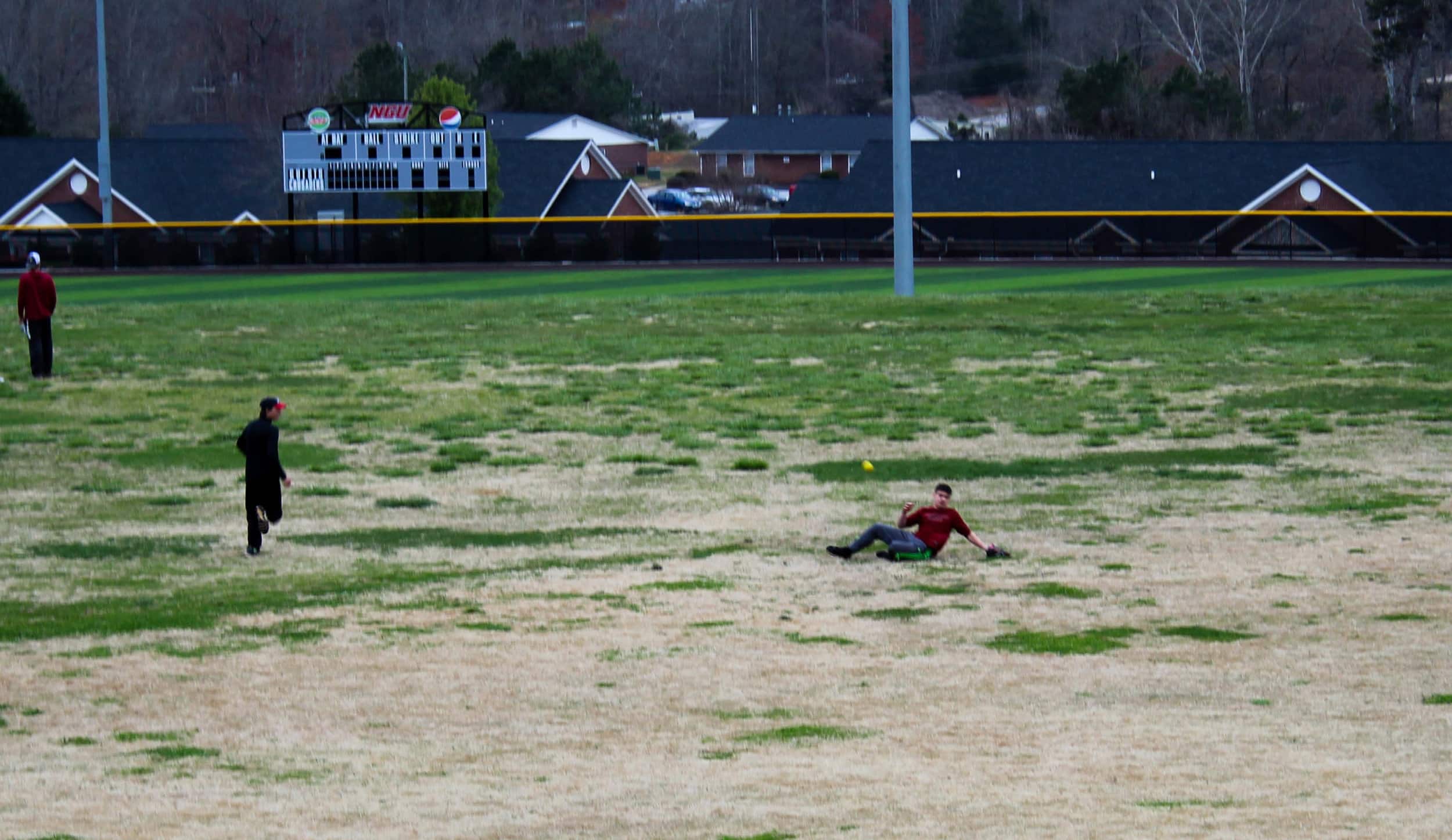 Austin Pittillo slides through the outfield hoping to get under the ball hit towards him.
