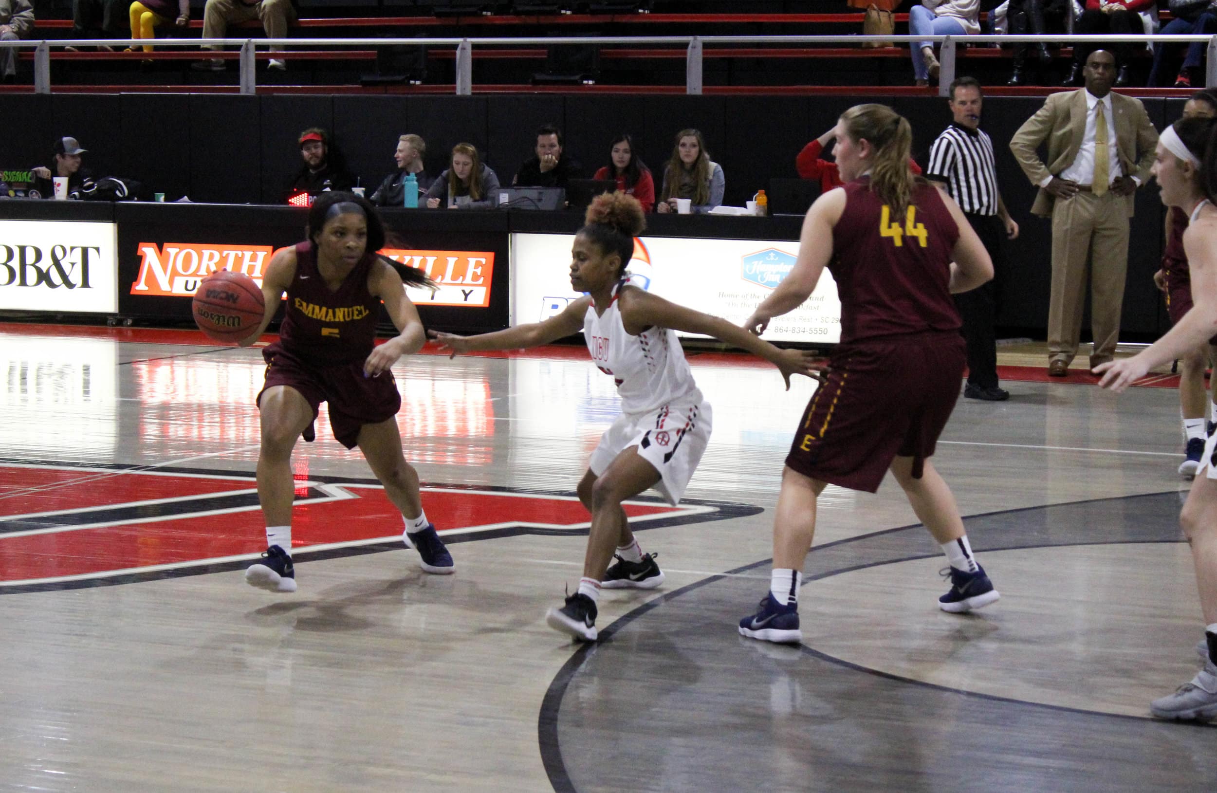 Savannah Hughes (21) breaks a pick set by a player on the other team and guards Emmanuels point guard as she dribbles down the court.