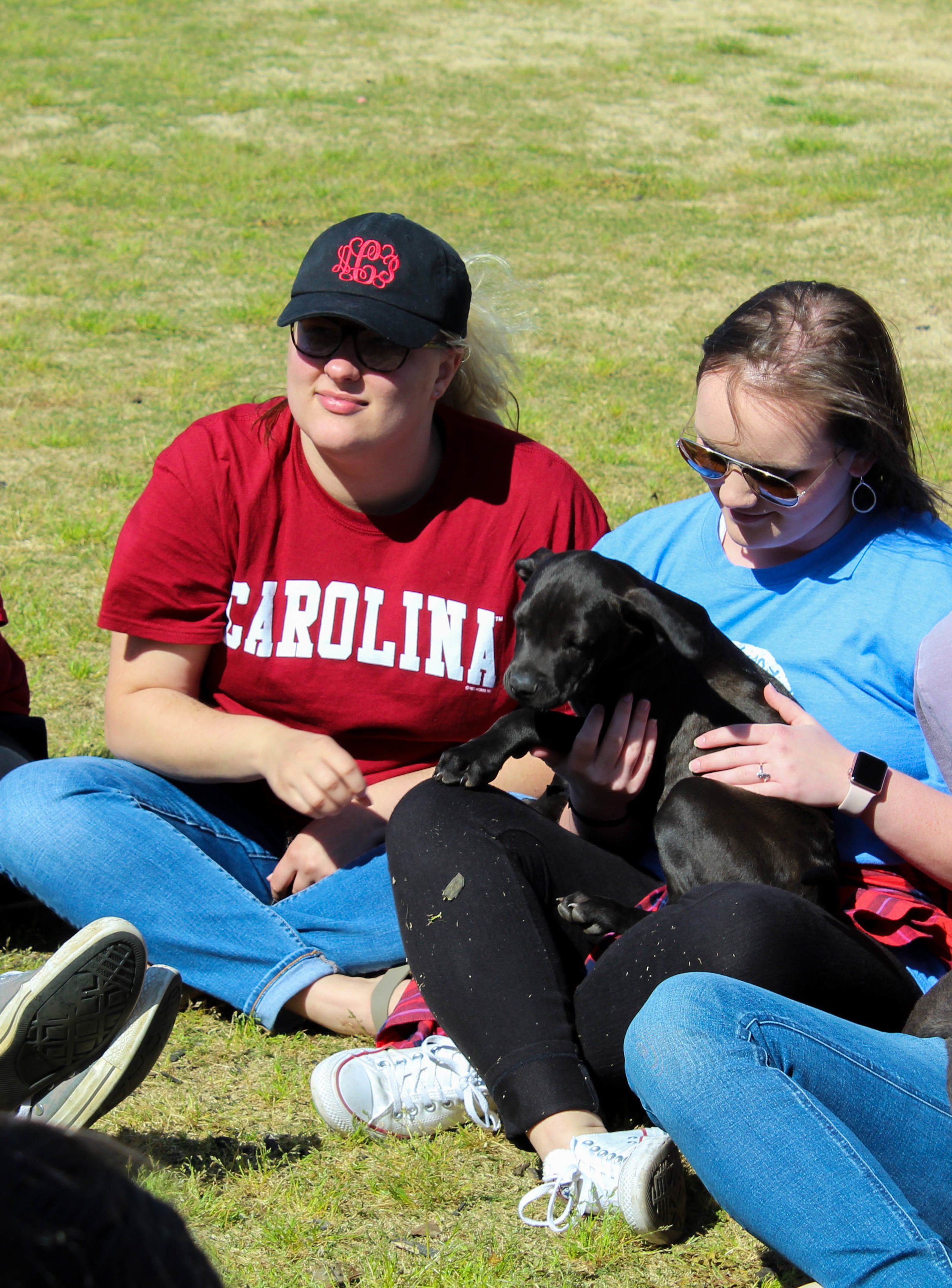 Freshman elementary education majors Allison Cantrell and Parker Foster pet a puppy.