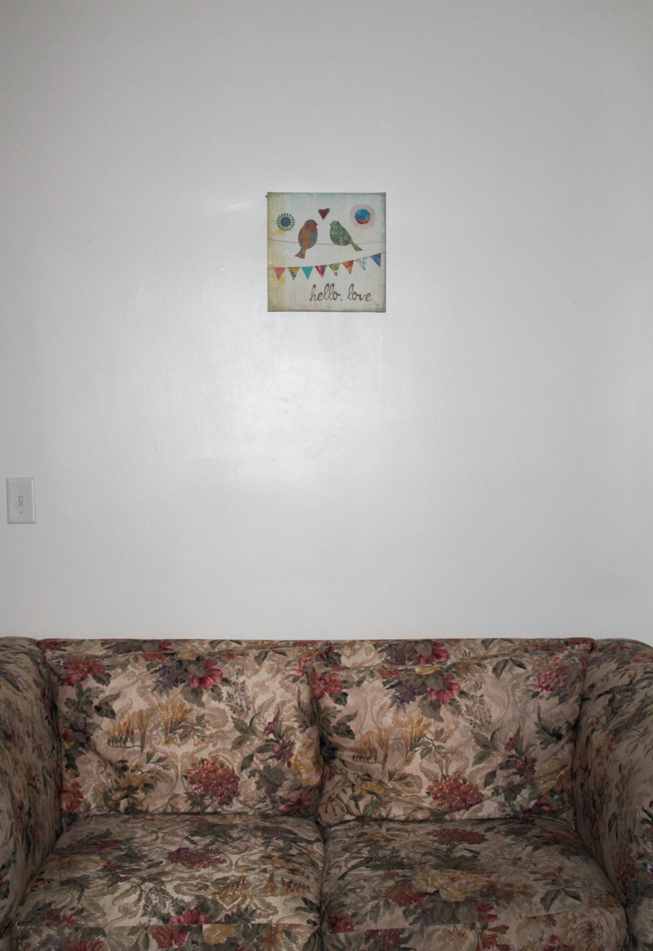 In a house on campus, the girls have a couch and wall art to make the room feel more like home.