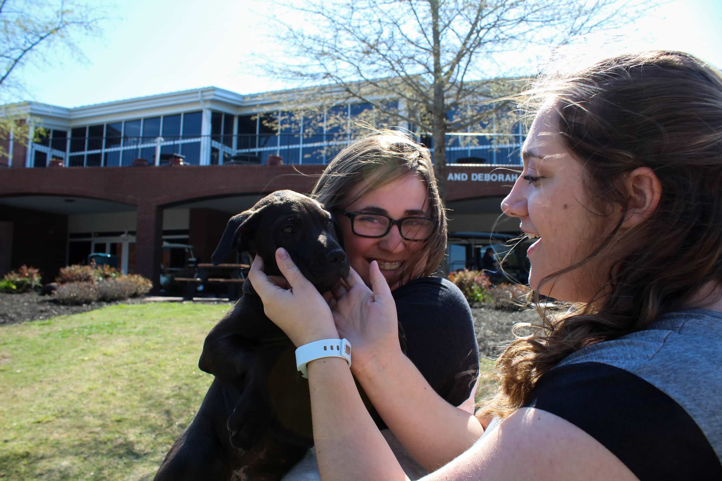 Holst and Pollard show one of the puppies affection as Holst holds her.