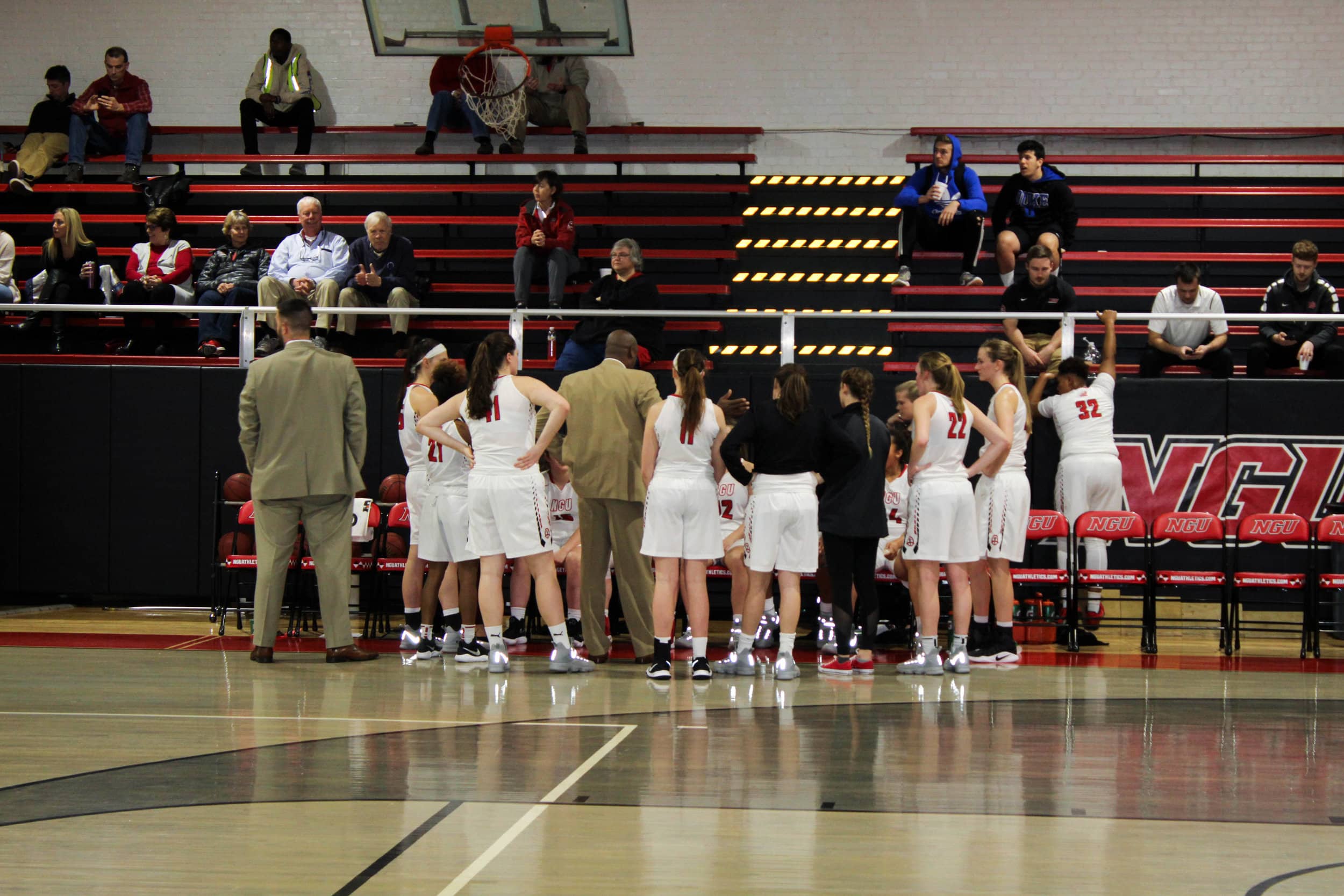 The NGU Womens Basketball team huddles together during a time out to listen to their coach.