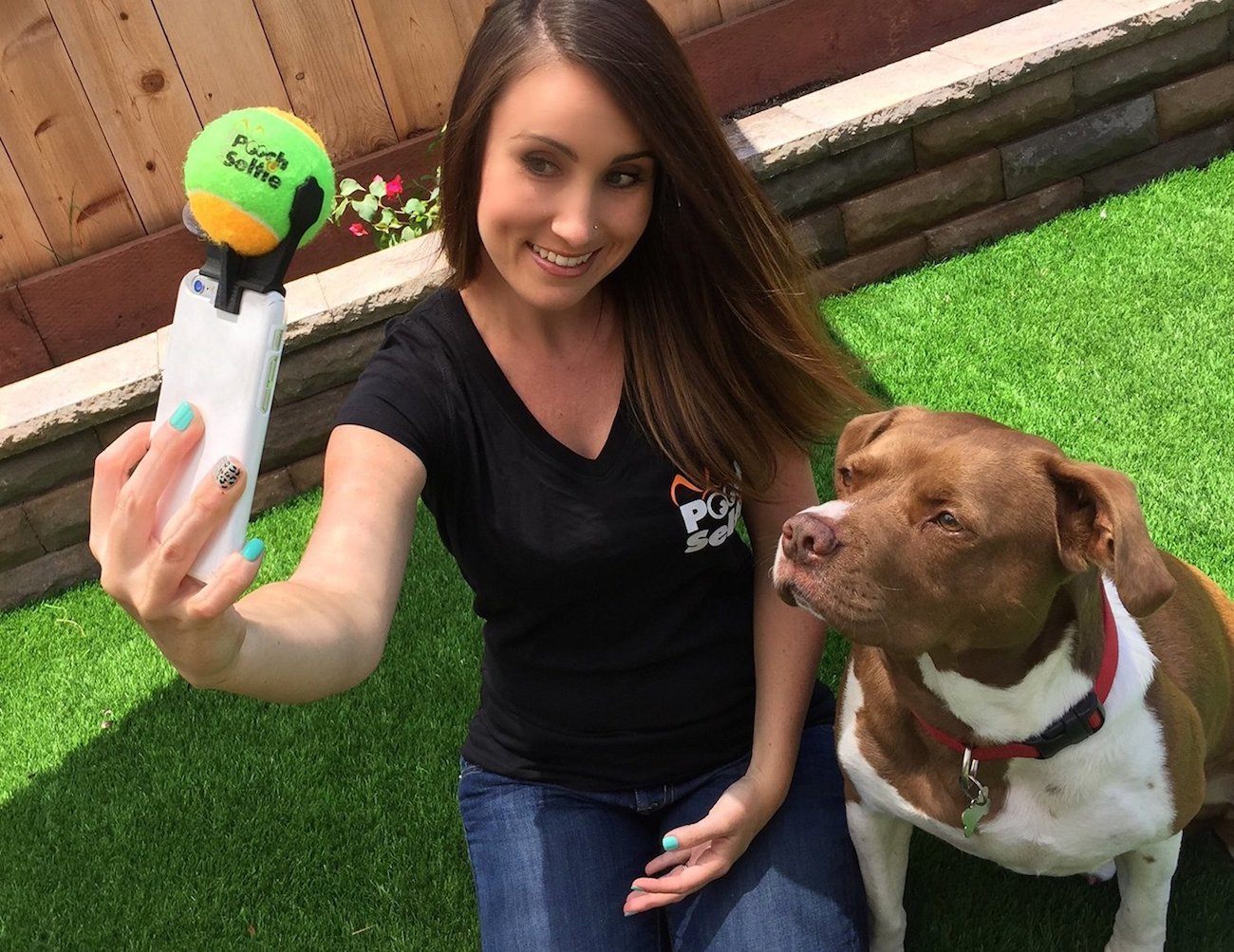 Dog lover poses with her pet using the puppy selfie stick.&nbsp;Source: GadgetFlow
