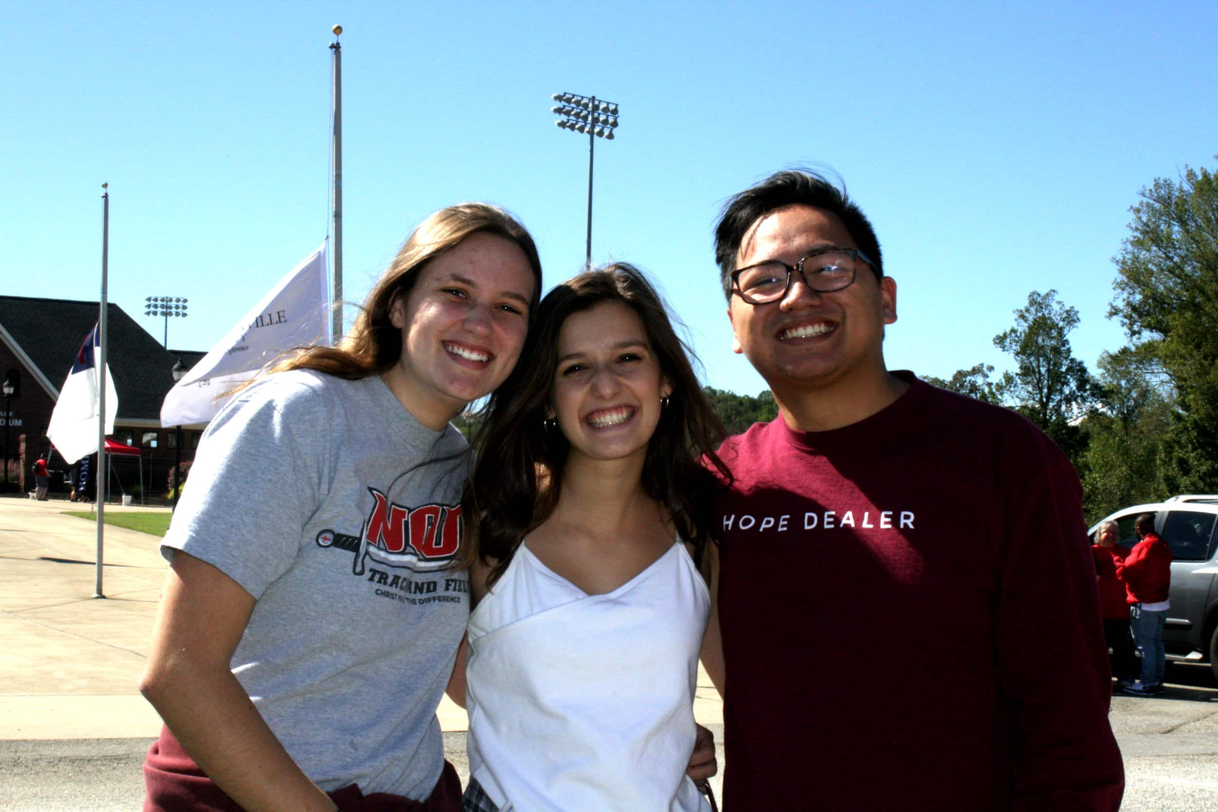 From left to right, students Caroline Smith (Sophomore), Abbey Blackwood (Senior) and Kieffer Mendoza (Alumni) enjoy the tailgate as they wait for the parade to start.