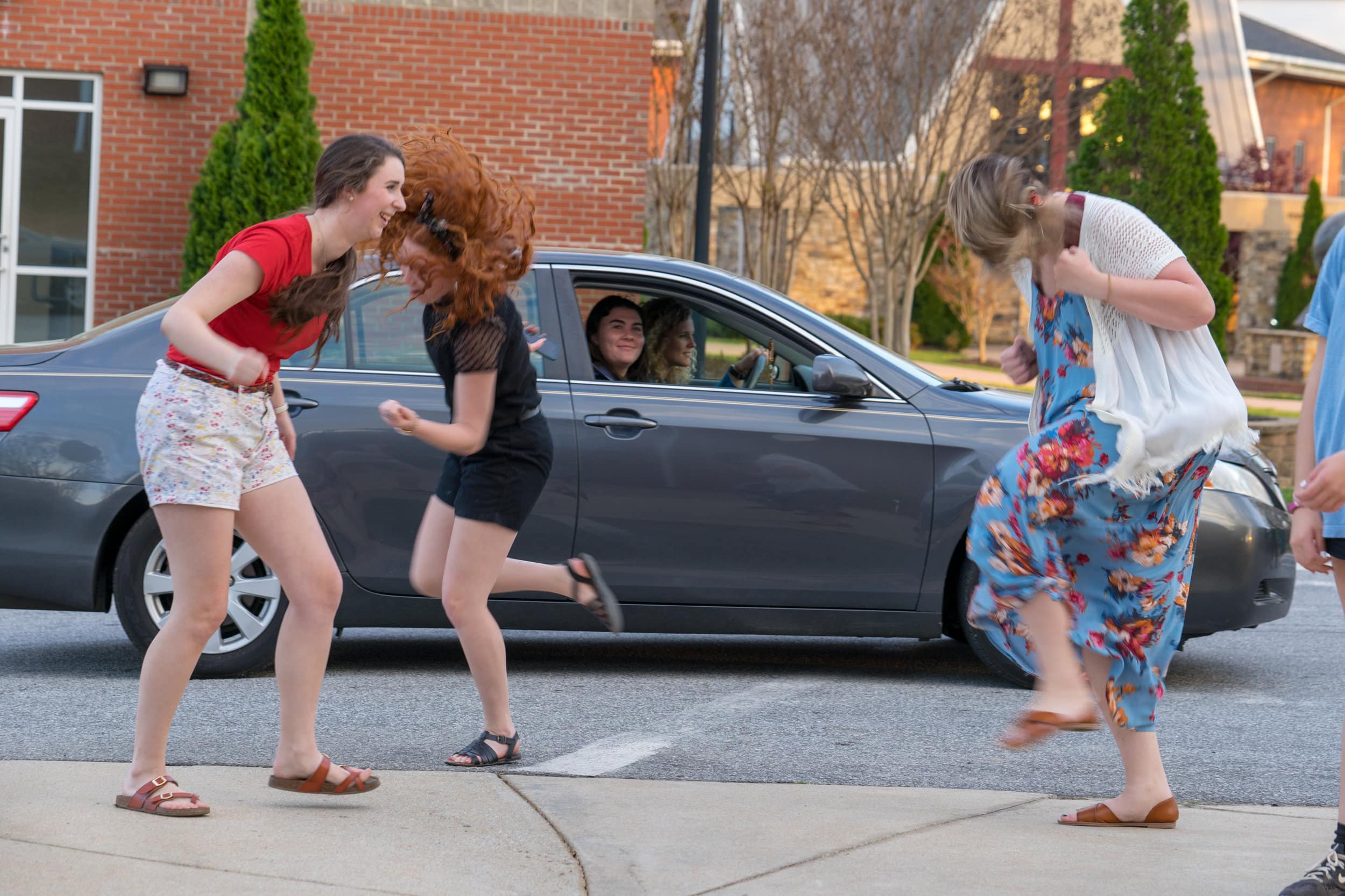 A group of NGU students dance like crazy as friends pass by jamming out.