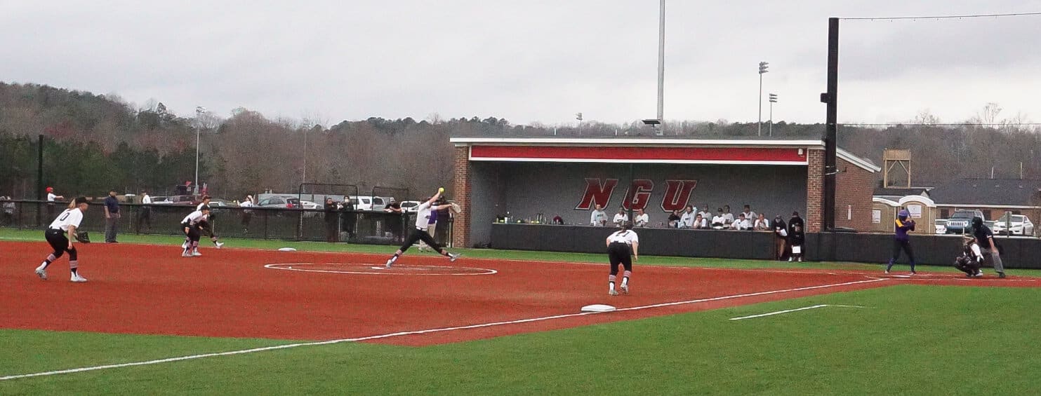 The outfielders get ready for the hit as sophomore Morgan Hatchell throws the pitch.