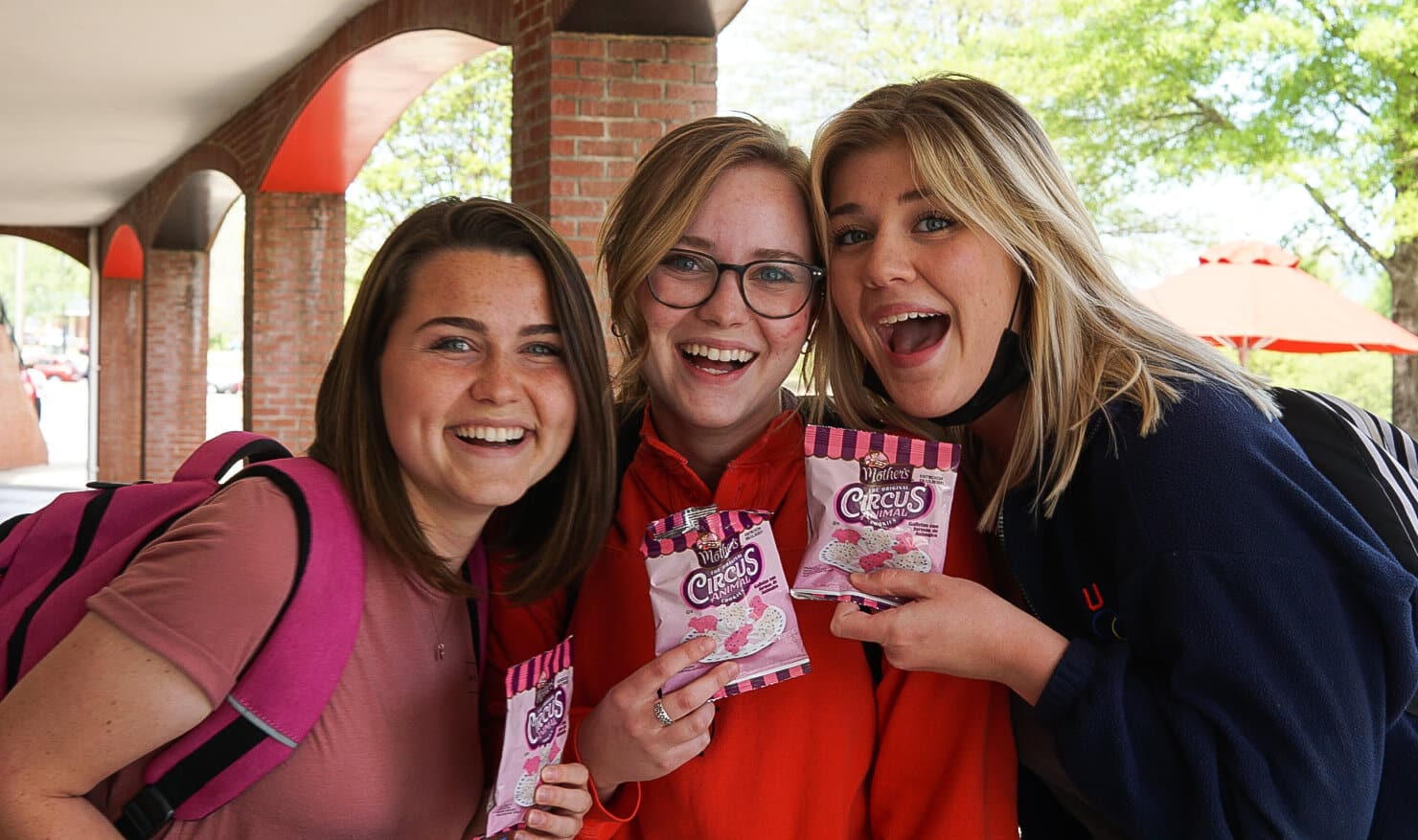 Sophomore elementary education majors Tara Madeira and Ruth Evans pose with junior business administration major Jordan Pracht after getting their free snacks.