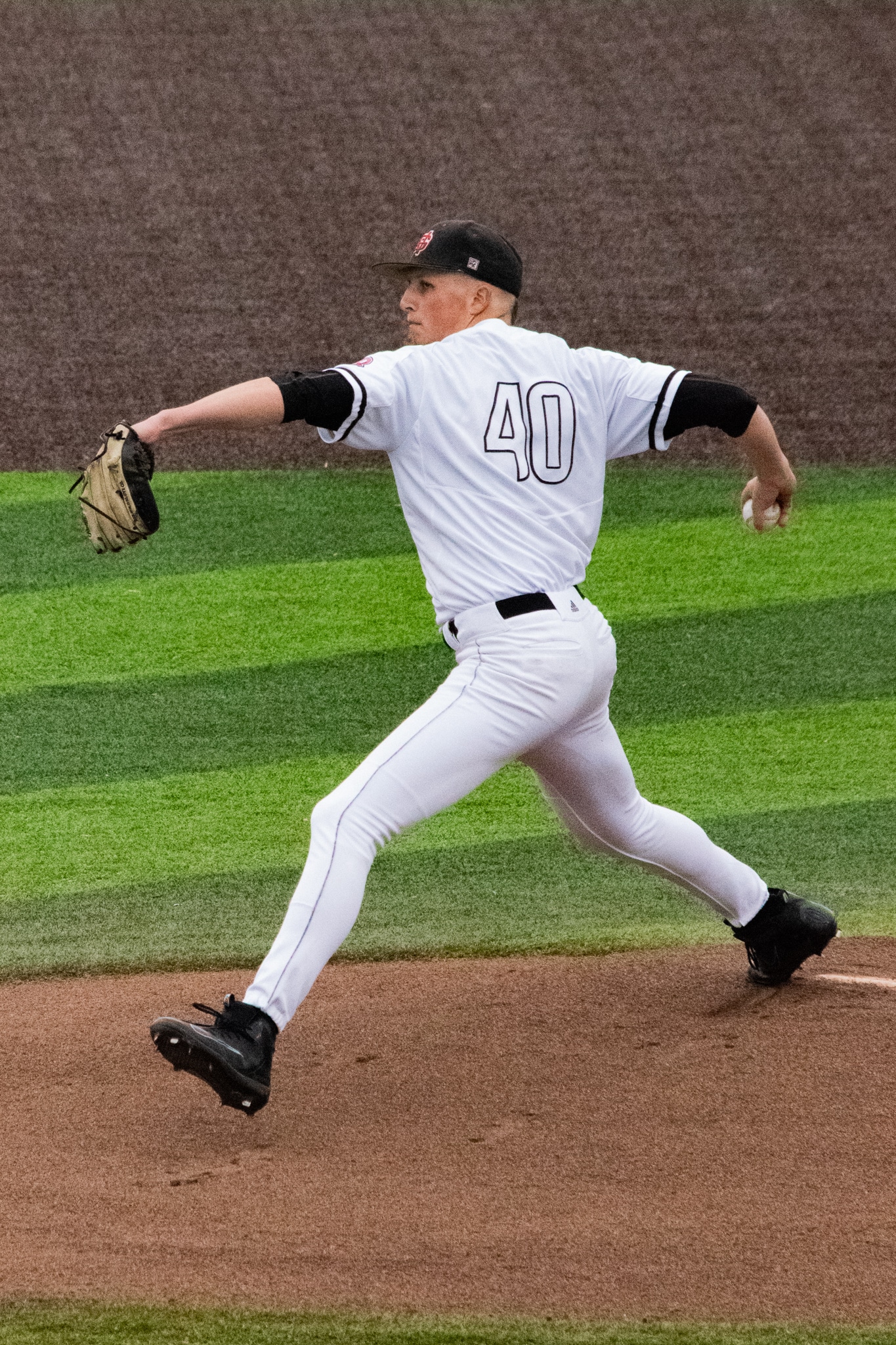 Senior Tucker Burgess (40) sends the first pitch of the game flying into the strike zone.