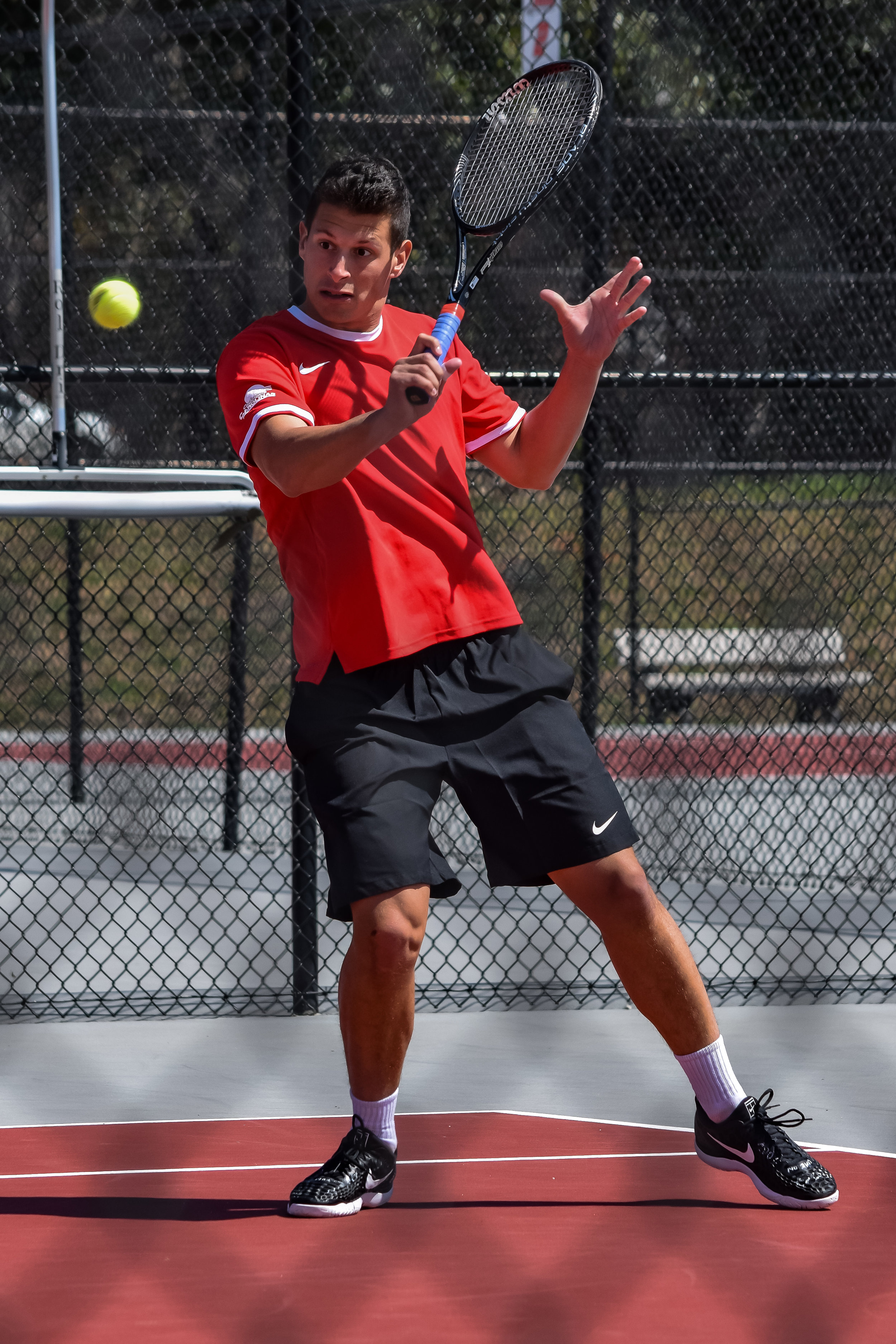 Freshman Giacomo Garini makes some wild faces while playing tennis.
