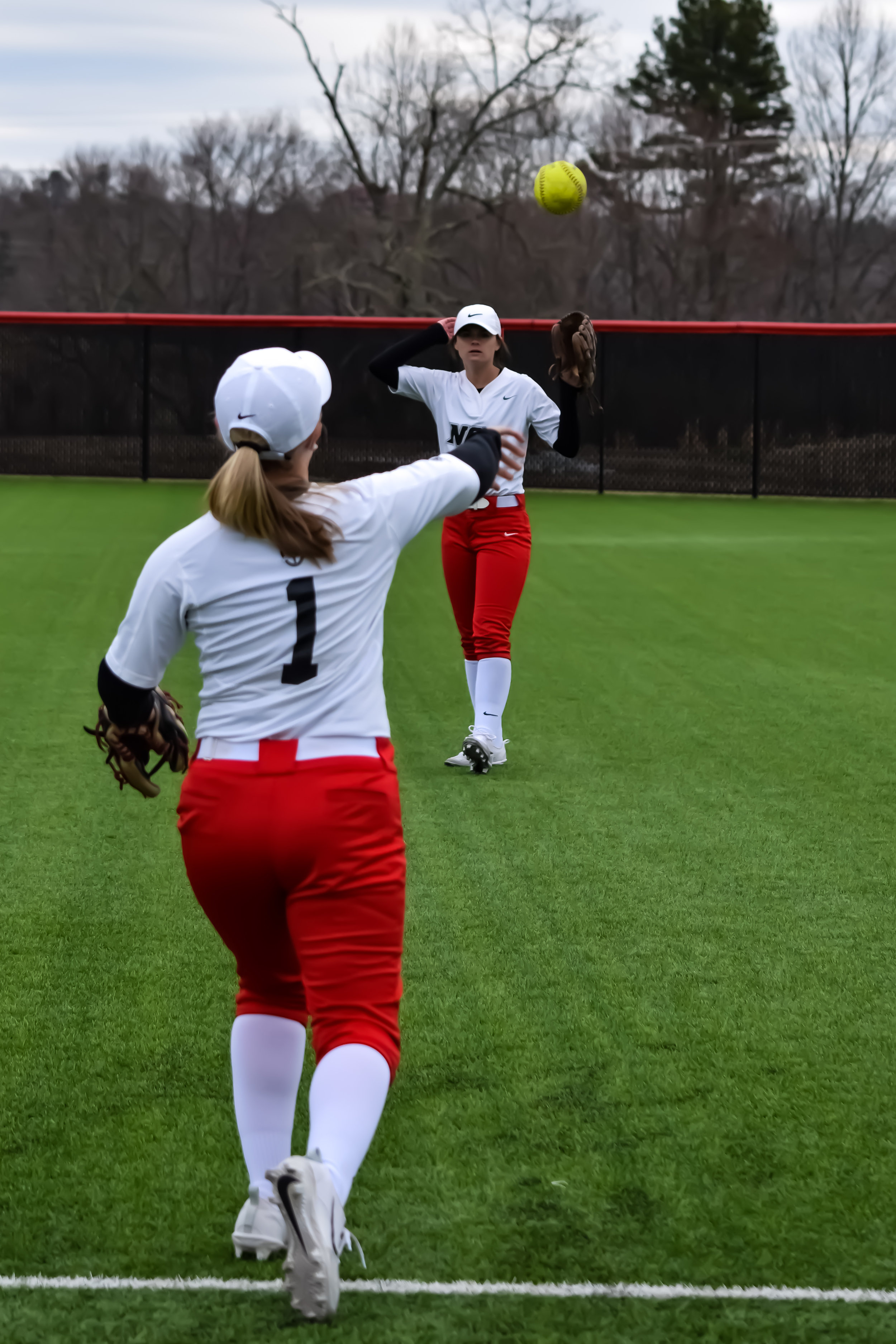 #11 Brooke Wade and #1 Ashton Withers throw the ball back in forth to warm up before the next inning.