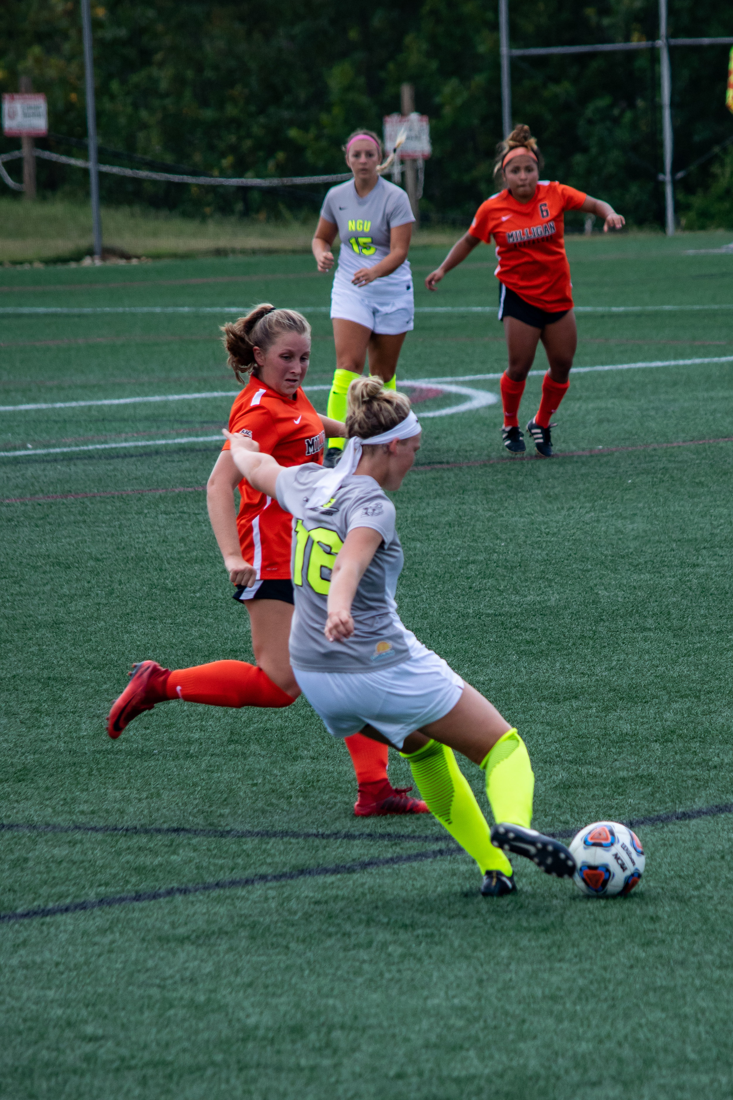 #16 Michaela Gleed prepares a strong kick to pass the ball to team member #15 Mackenzie Neff.