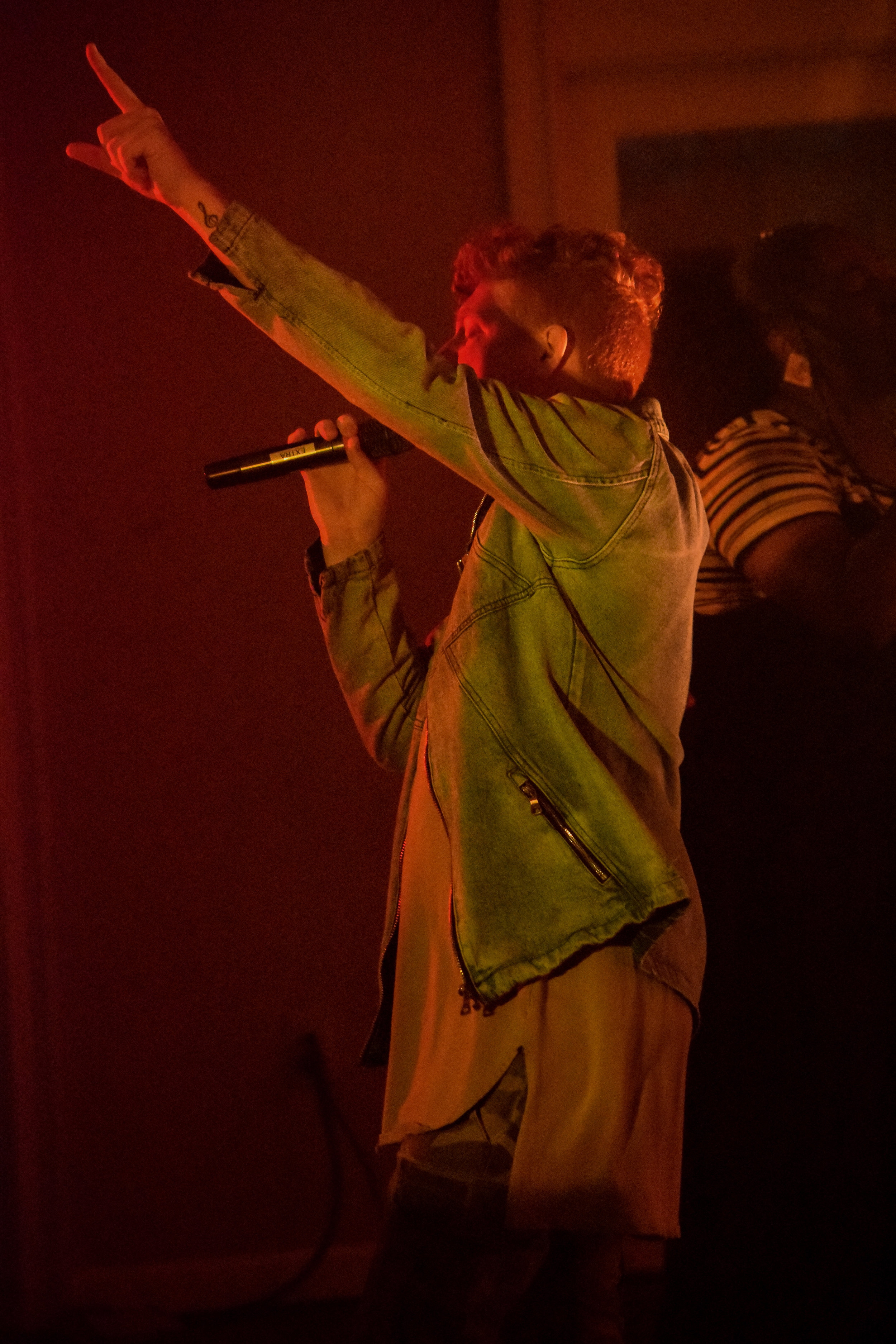 Senior singer Austin Painter raises his hand as he leads the crowd in worship.