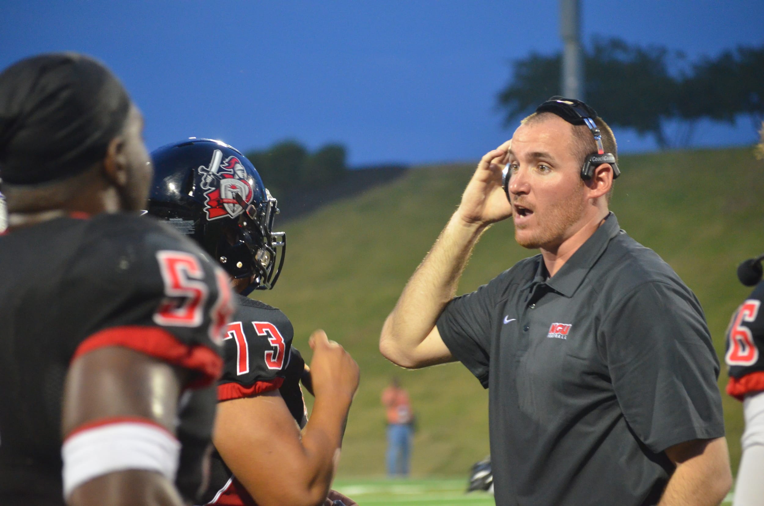  One of the coaches talks to some of the team before getting back on the field for the rest of the quarter 