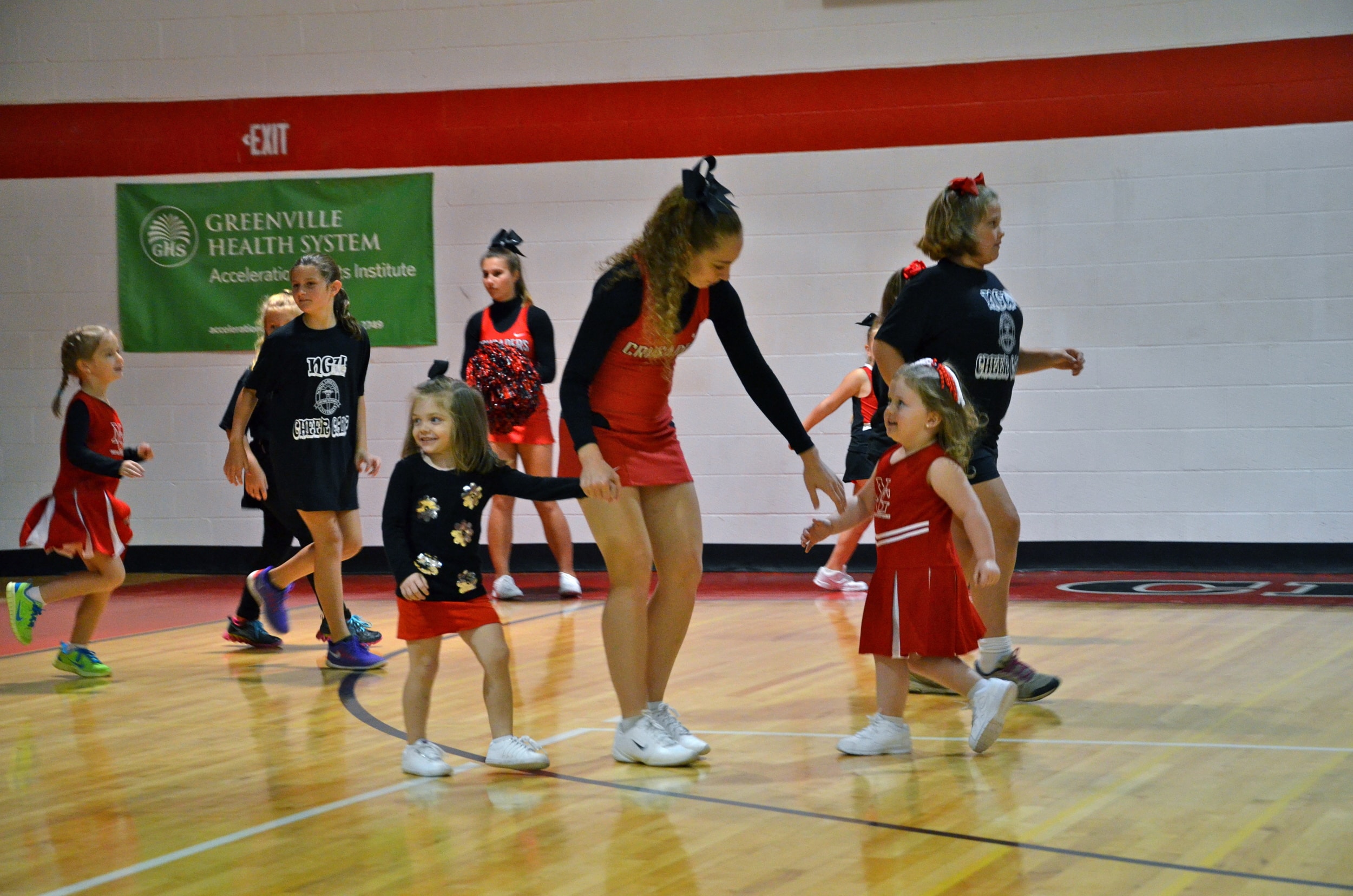  A cheerleader lends a helping hand to help the young cheerleader in the game. 