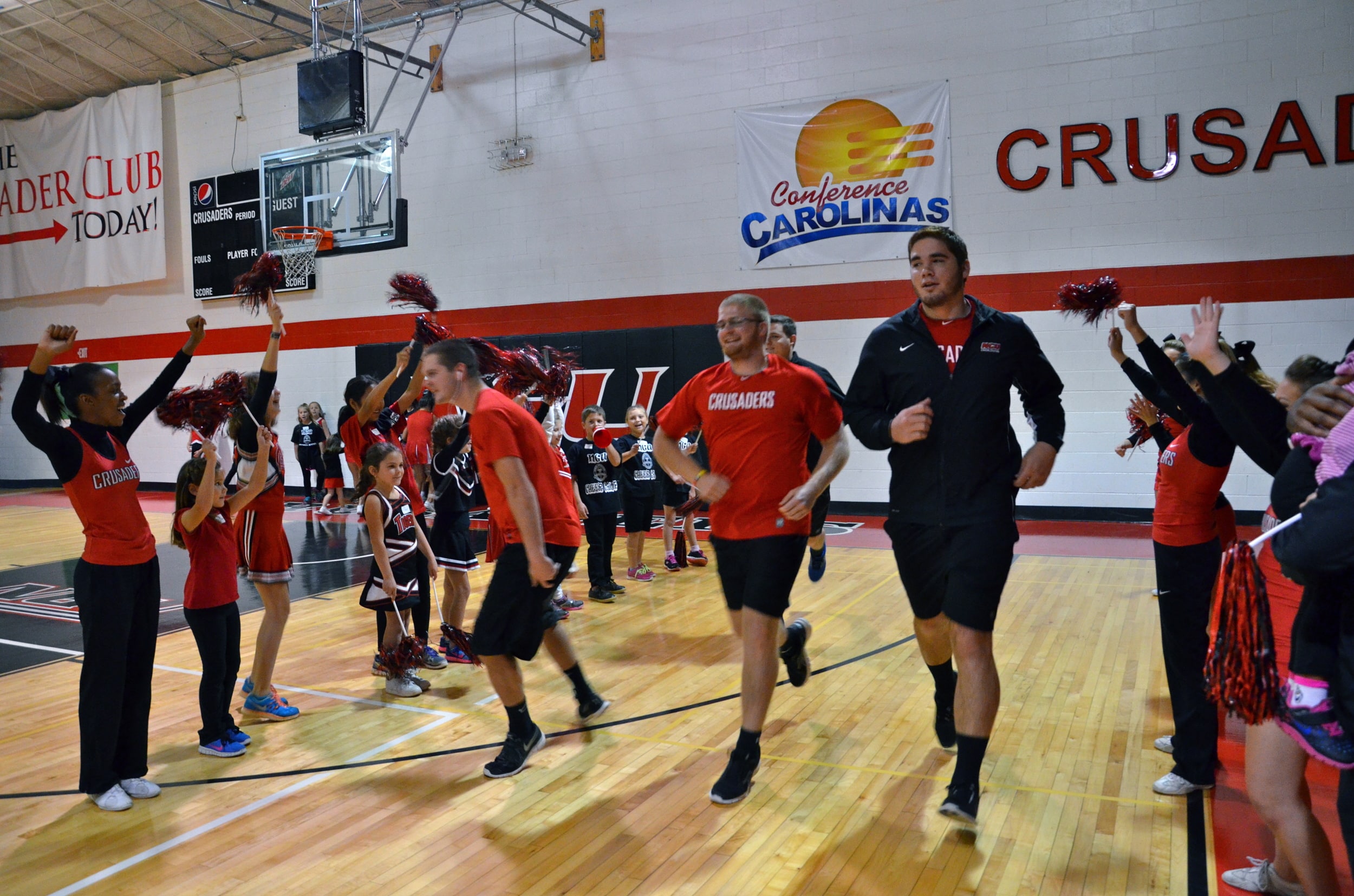  A tunnel of mini-Crusaders encourage the male cheerleaders as they run through. 