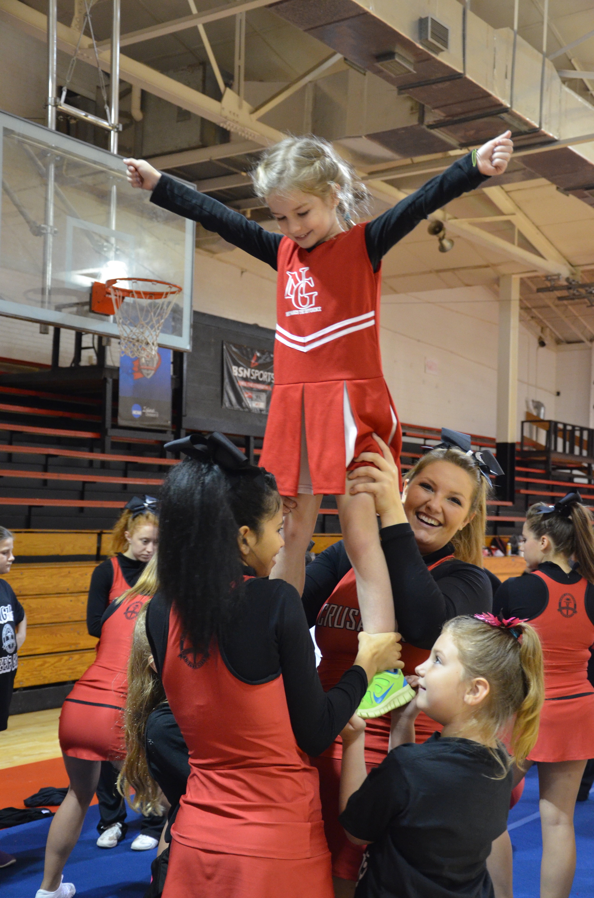  A little girl getting big help to be like the cheerleaders 