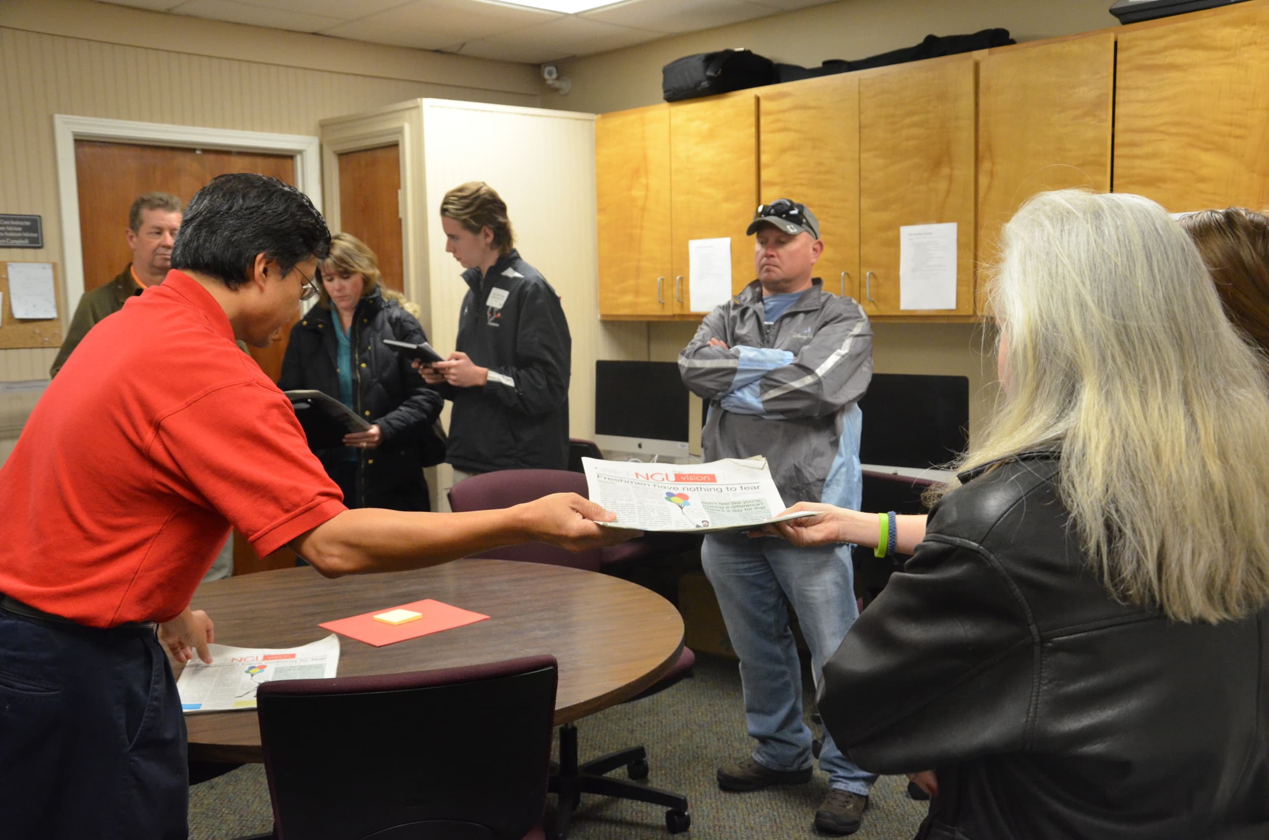  Dr. Ecarma, a Mass Comm. Professor, hands the most current edition of The Vision to a few guests. 