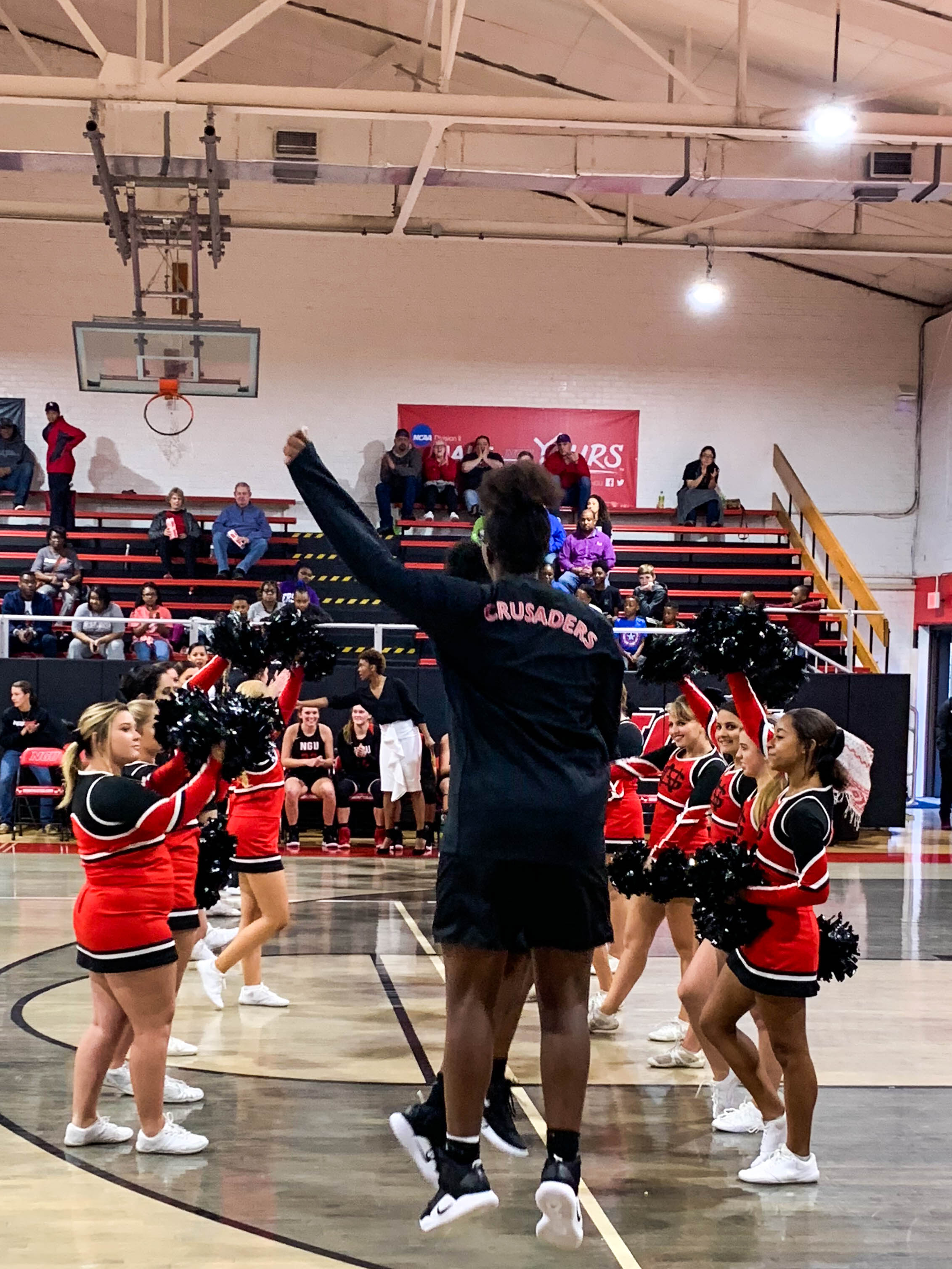 Freshman Asia Jones (24) chest bumps the starters for NGU as their names are called at the start of the game.