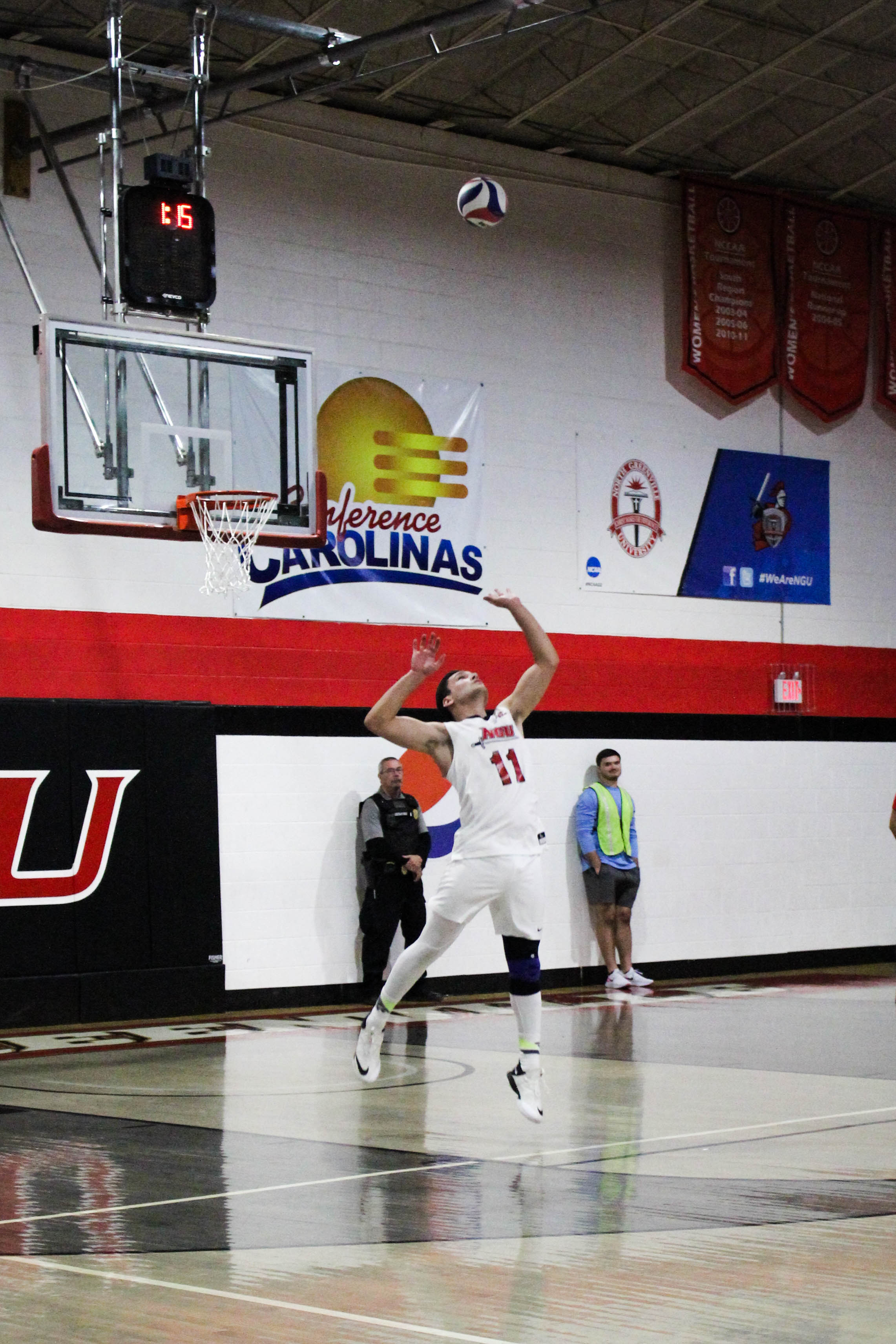 Freshman Cade McGee (11) serves the ball to the Trojans.