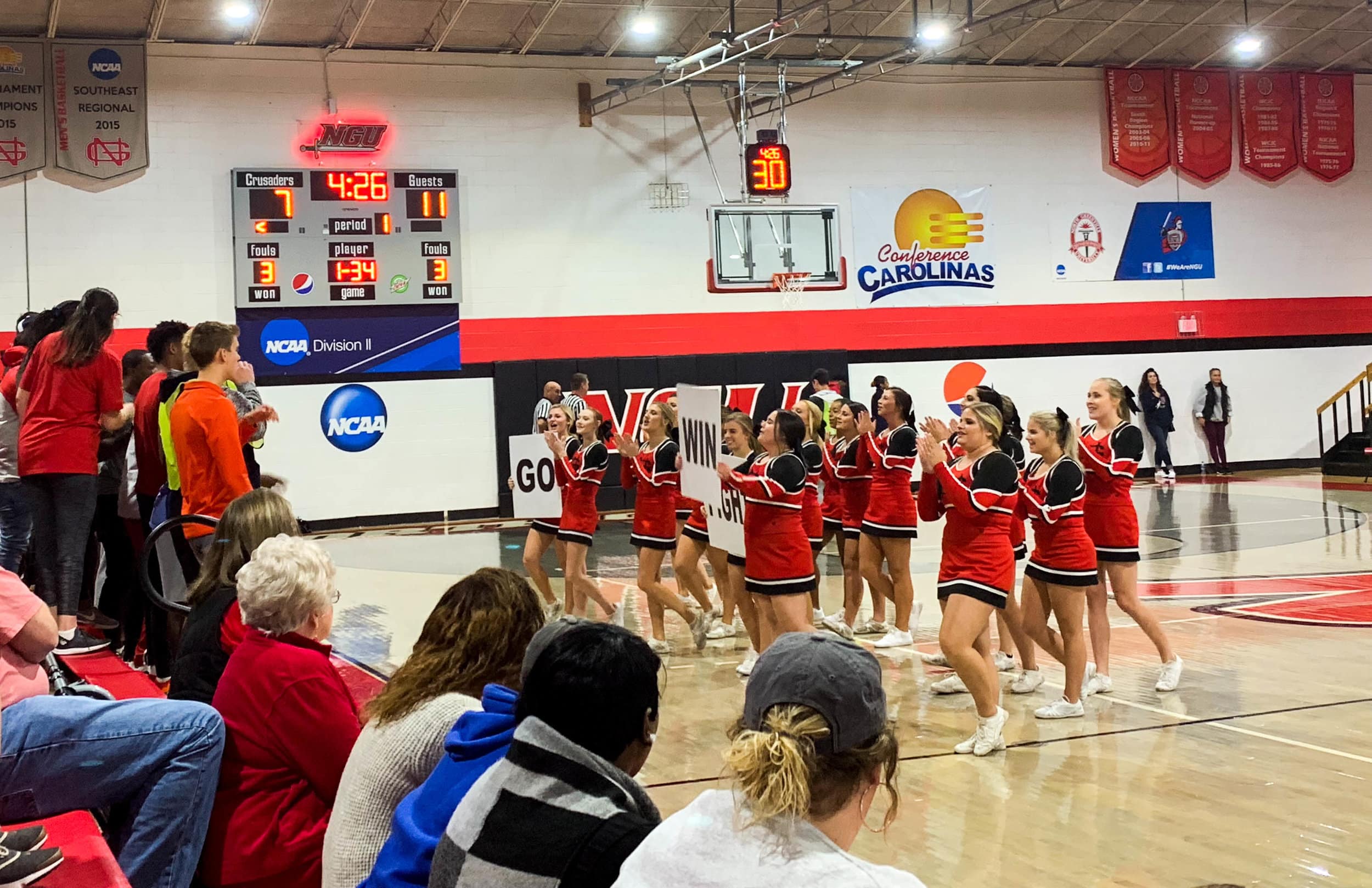 During a time out, the NGU cheerleaders take the court in front of the student section to lead them in a cheer.