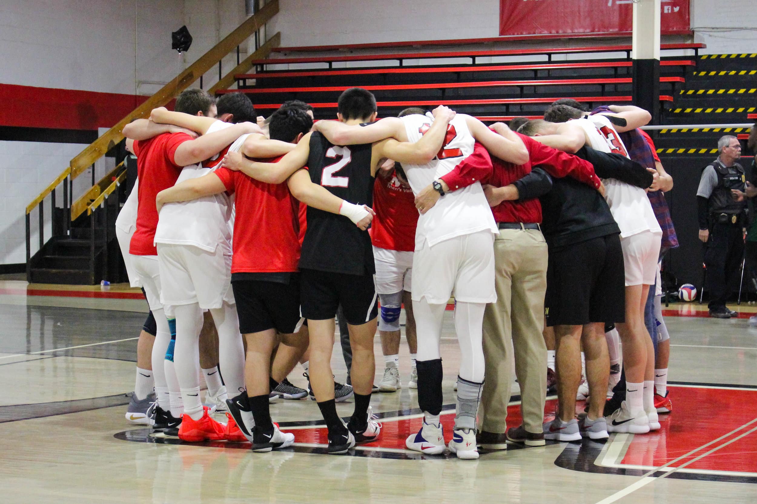 The Crusader mens volleyball team huddle together to pray after the game.