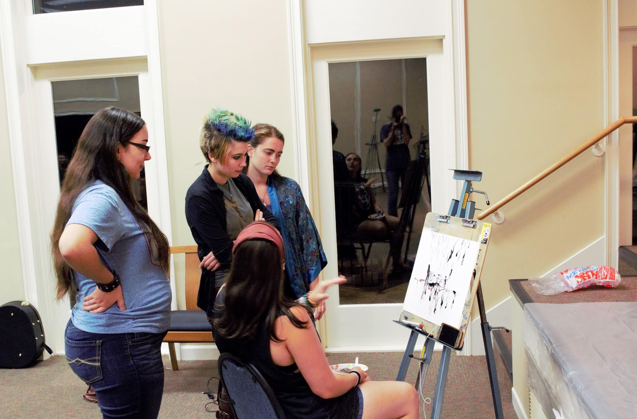  Students talk and discuss with Kat Fricault about her marker-made drawing.&nbsp; 