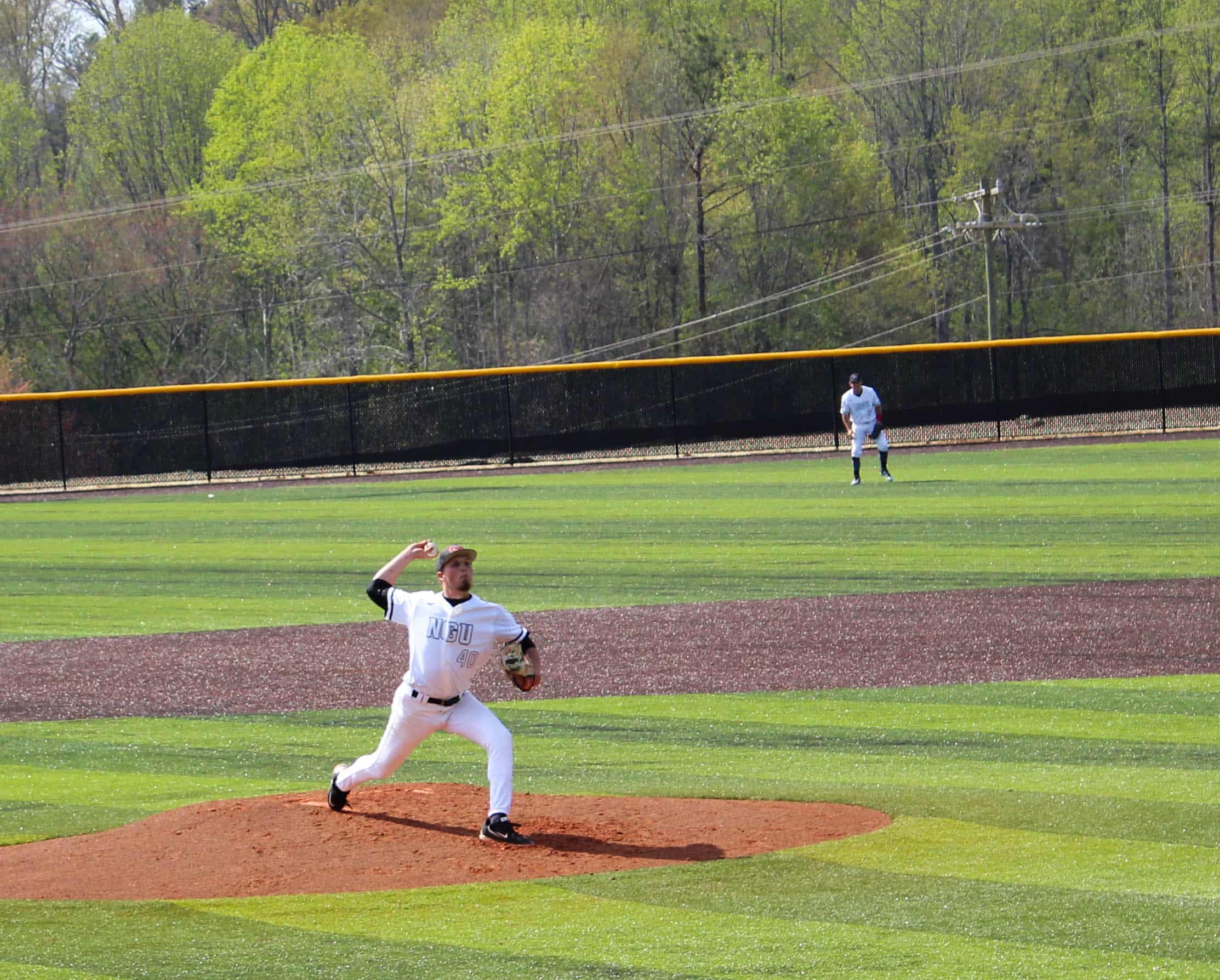 Burgess, a right handed pitcher, throws the ball to the batter.