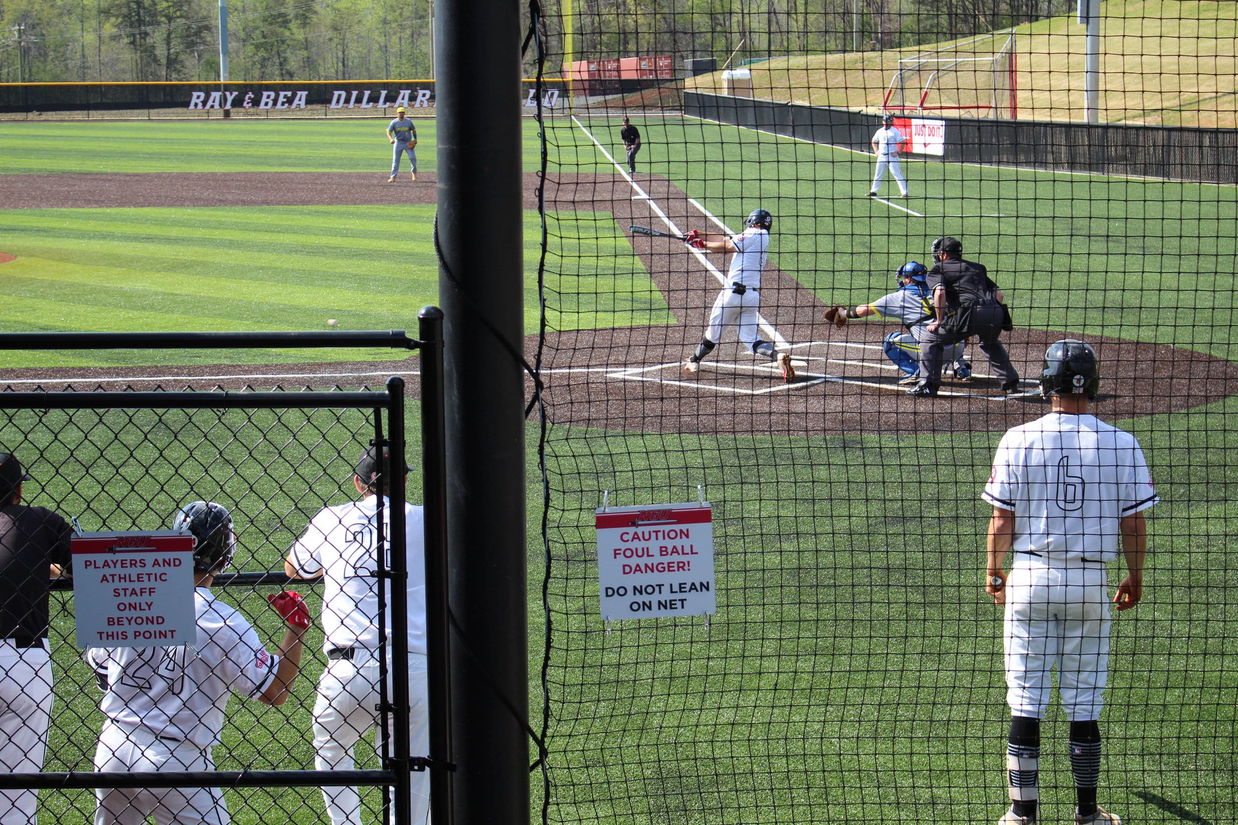 An NGU player hits the ball as Connor Grant stands on deck getting ready to bat next.