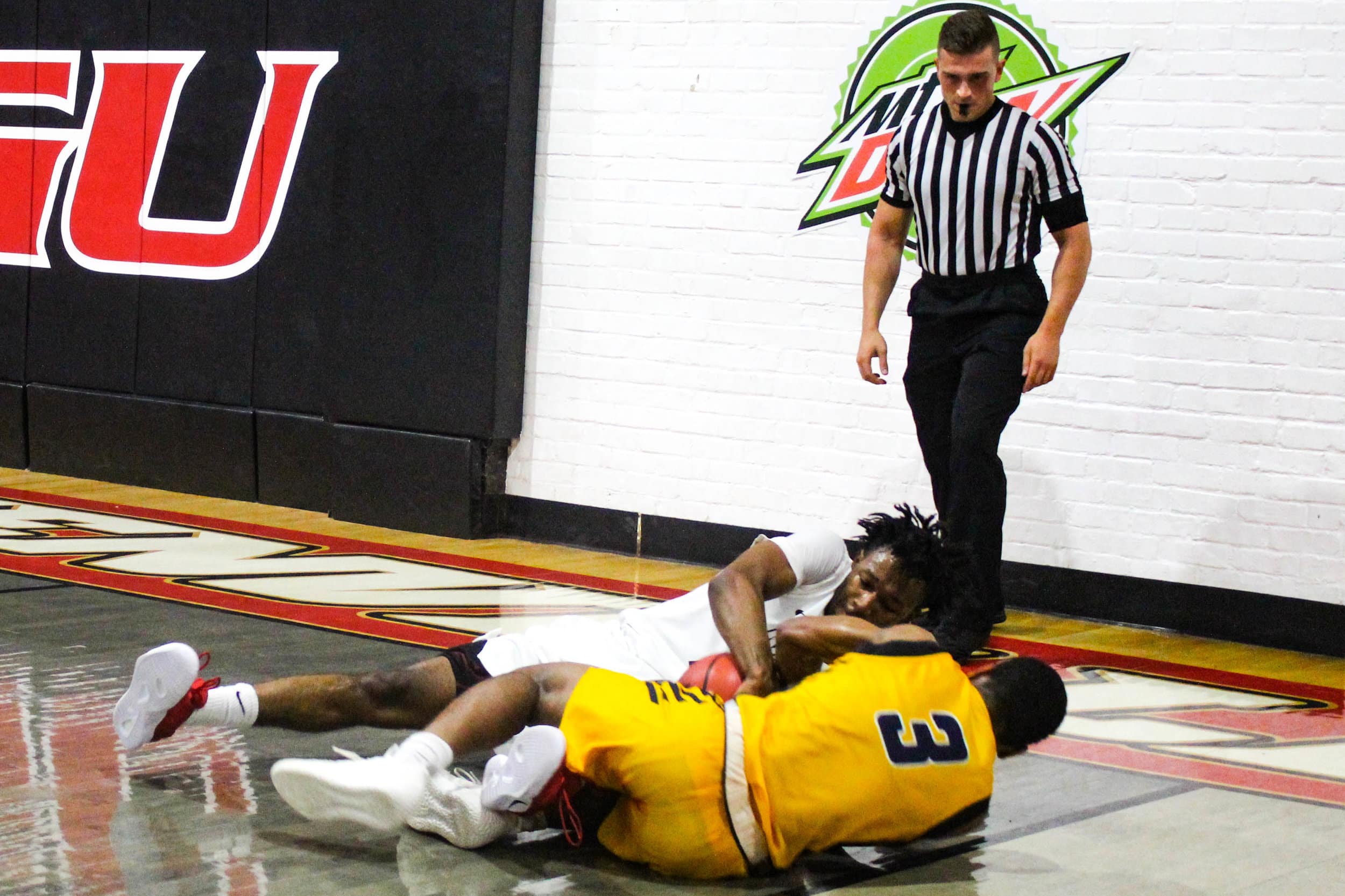 Mobley (15) and a player for CIU fight on the ground for possession of the ball.