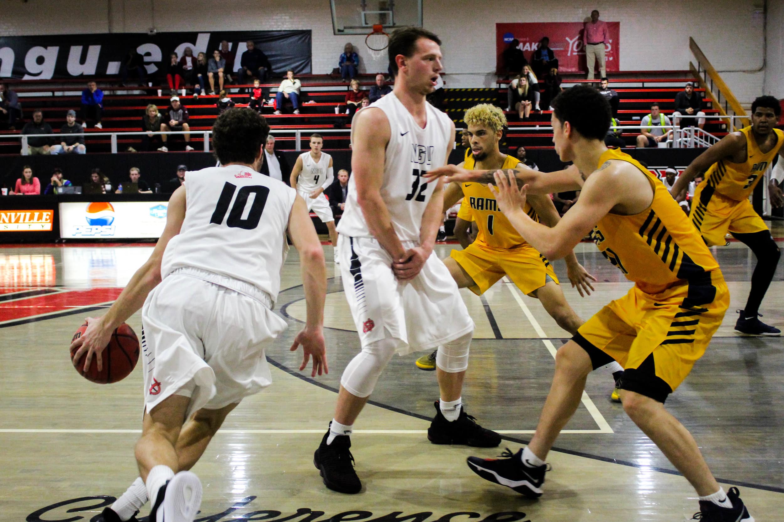 Junior, Spencer Kirkpatrick (32) sets a pick to free freshman Caleb Arrington (10) from his defender.