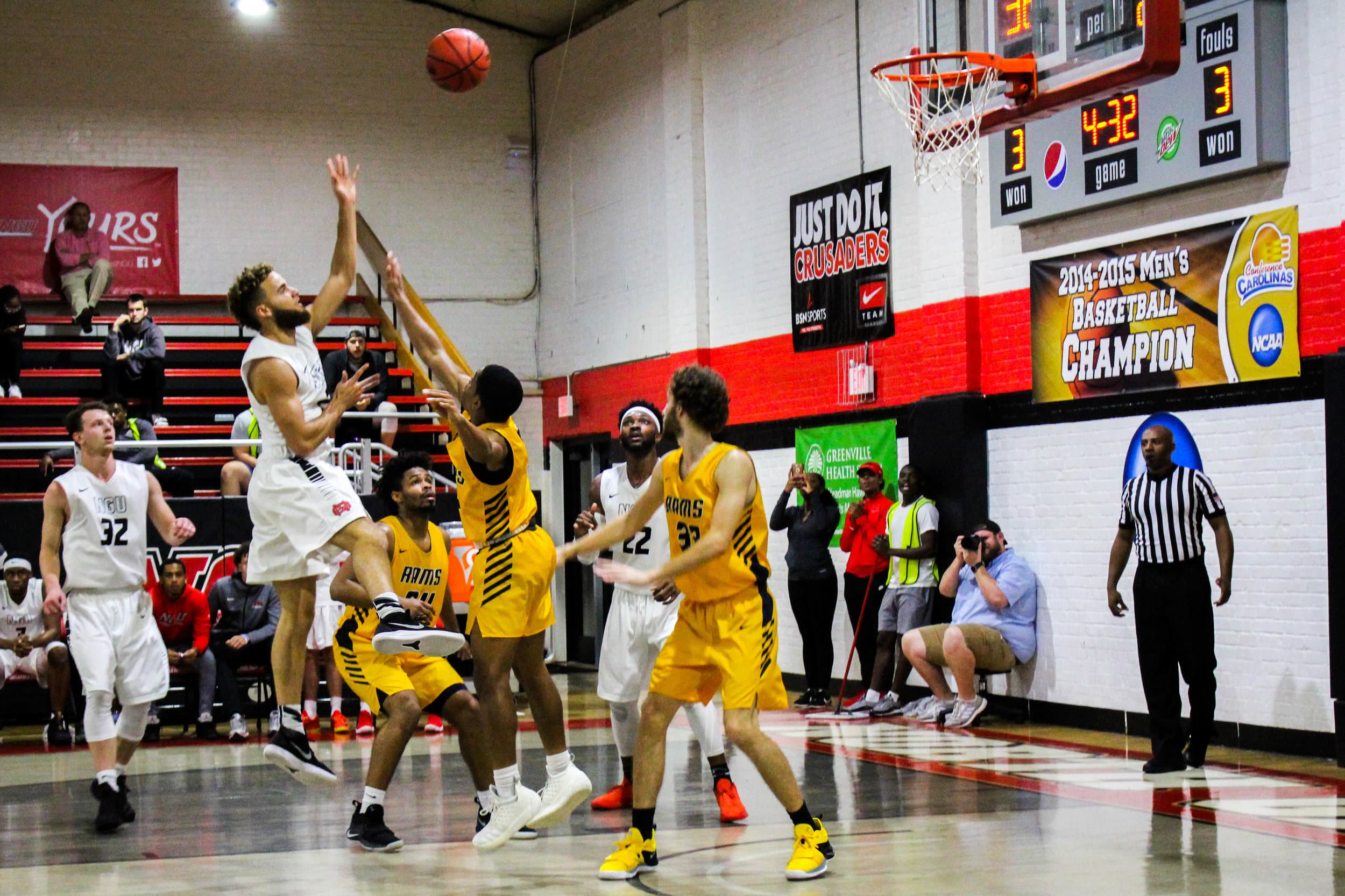 Myers (21) shoots a jump shot while being guarded by multiple defenders.