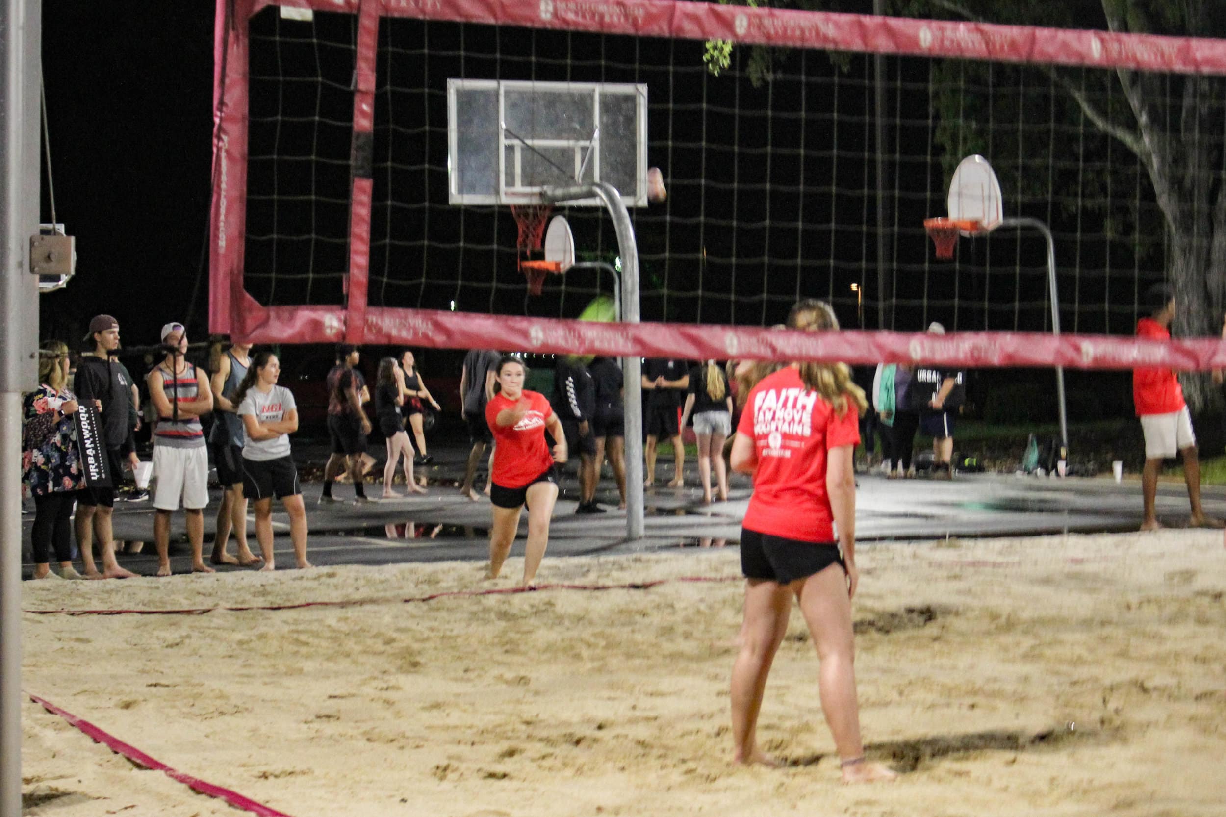 While playing against the animal science club, a member of the campus ambassadors serves the ball.