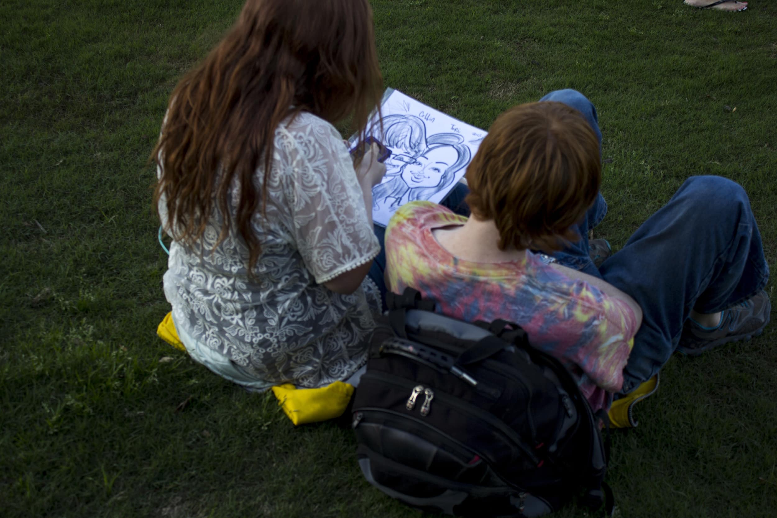  These two students enjoyed sitting in the grass after getting their own caricature drawn. 