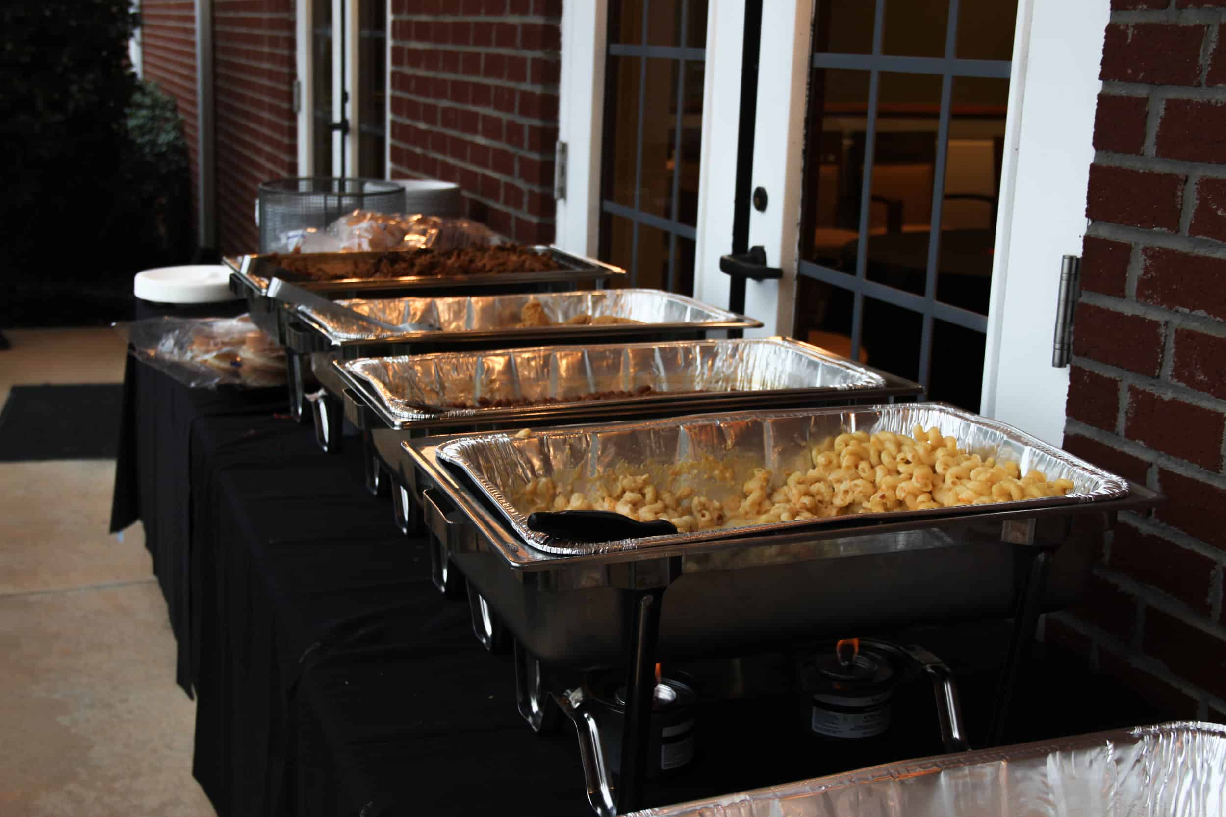 Barbecue, chicken fingers, beans and macaroni and cheese being served for dinner.