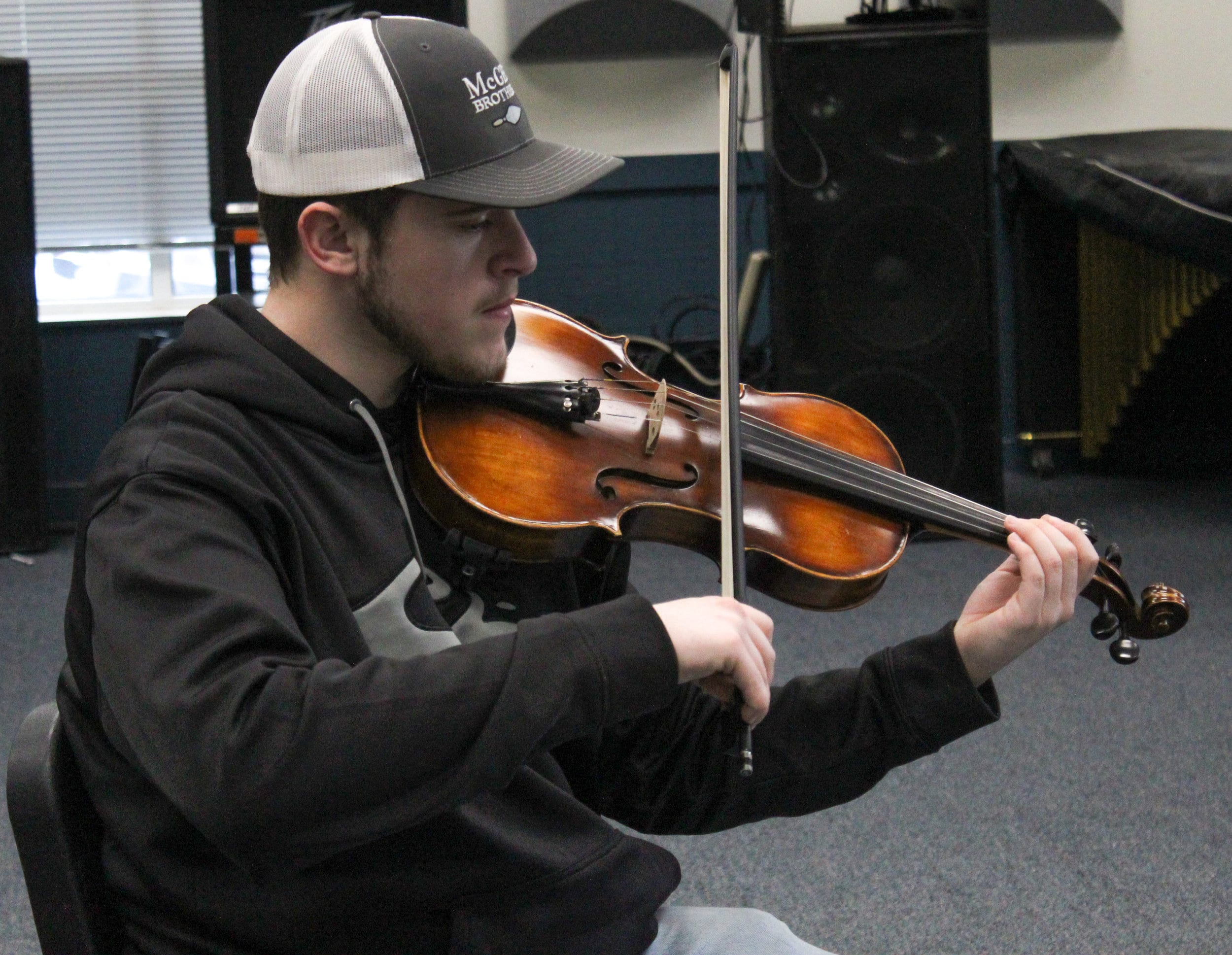 Brandon McAlister plays along with the orchestra using the violin.
