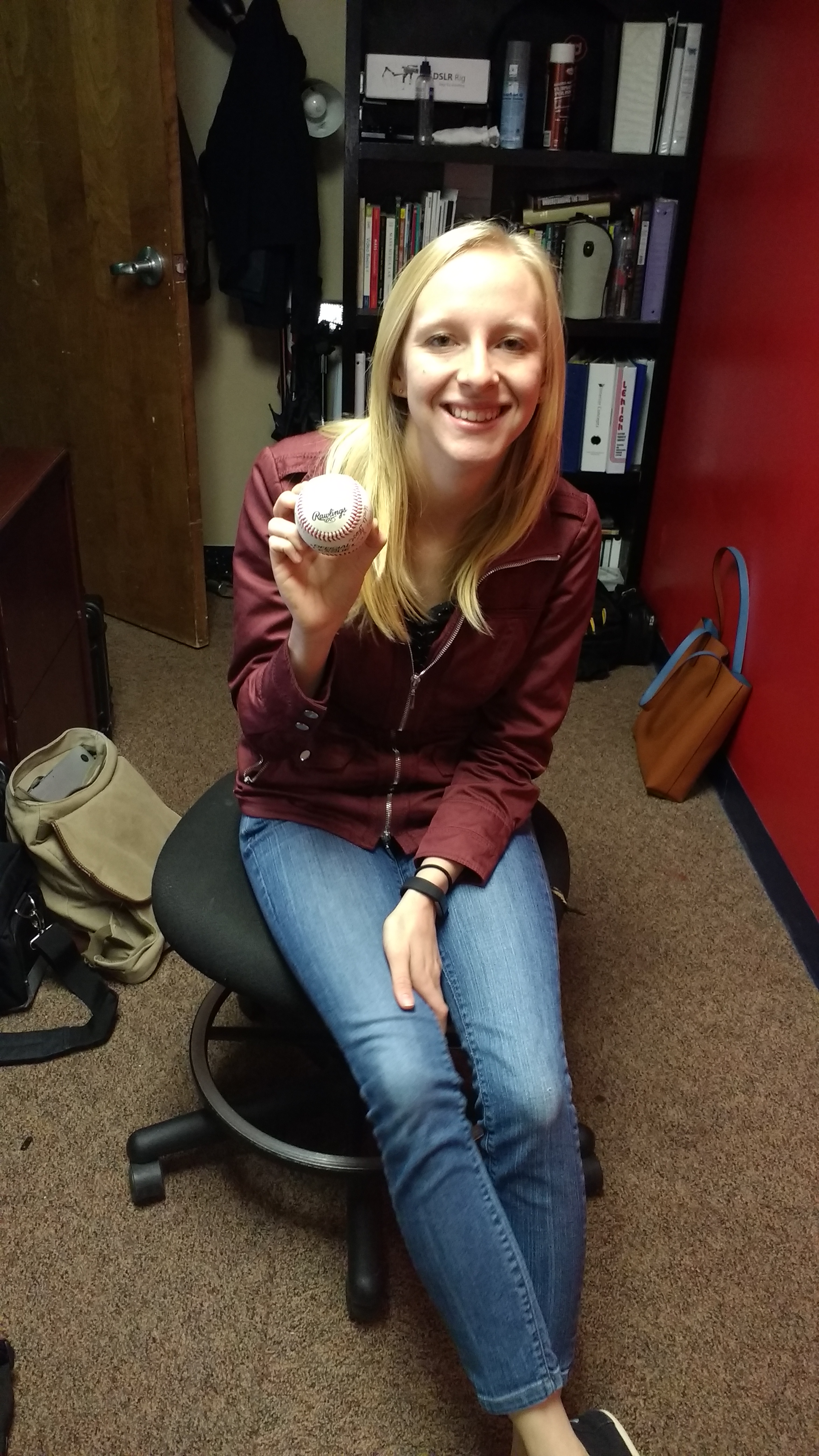 Mary Erny ('16 - Broadcast Media)&nbsp;holding her favorite gift. A baseball signed by all of her family members.&nbsp;