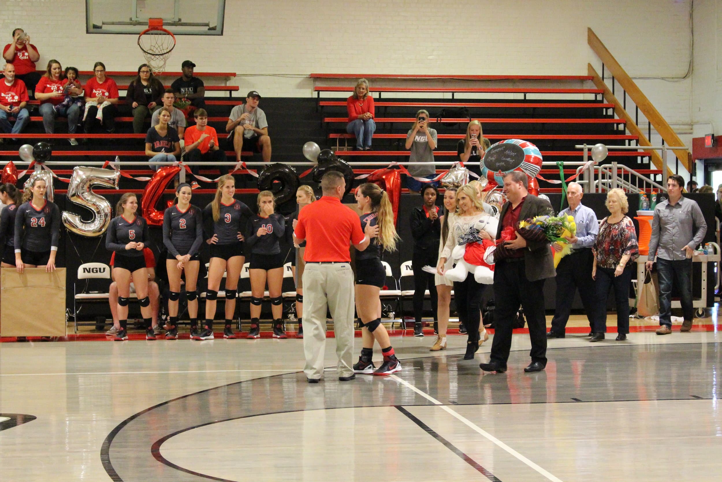  Coach Greg Mosley congratulates each senior with a framed jersey with their volleyball number. 