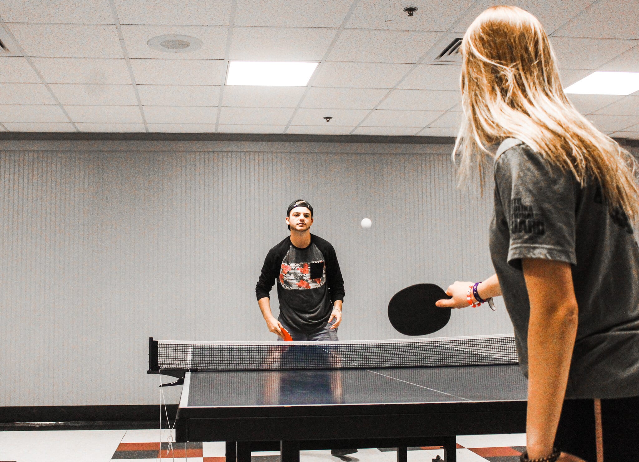 Jonathan Hannah, Sports Management major and Sydney Ackerman, Psychology major, play ping pong in the game room.