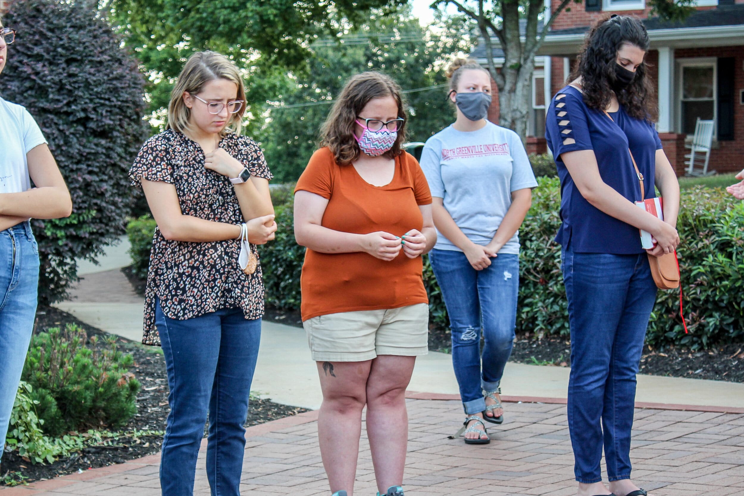 A group of girls bowed in prayer. BCM emphasizes community building, and through this event many are able to grow in their spiritual walks together.
