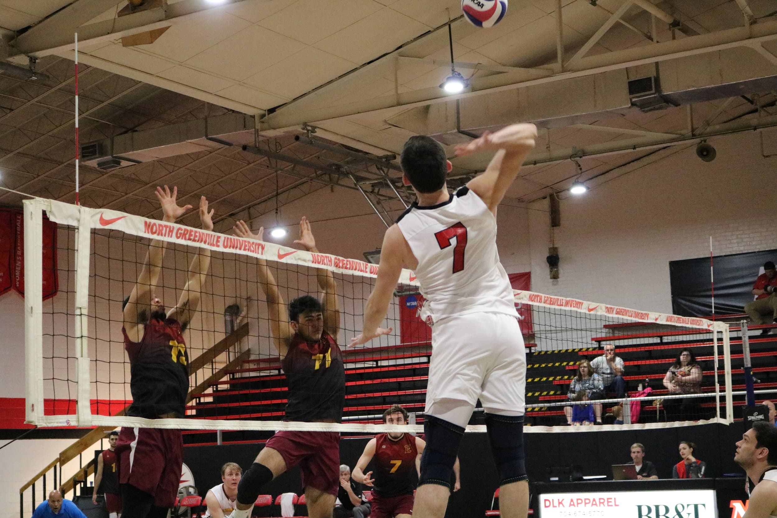 Junior Jackson Gilbert (7) jumps to spike the ball over the net in the first set of the game.