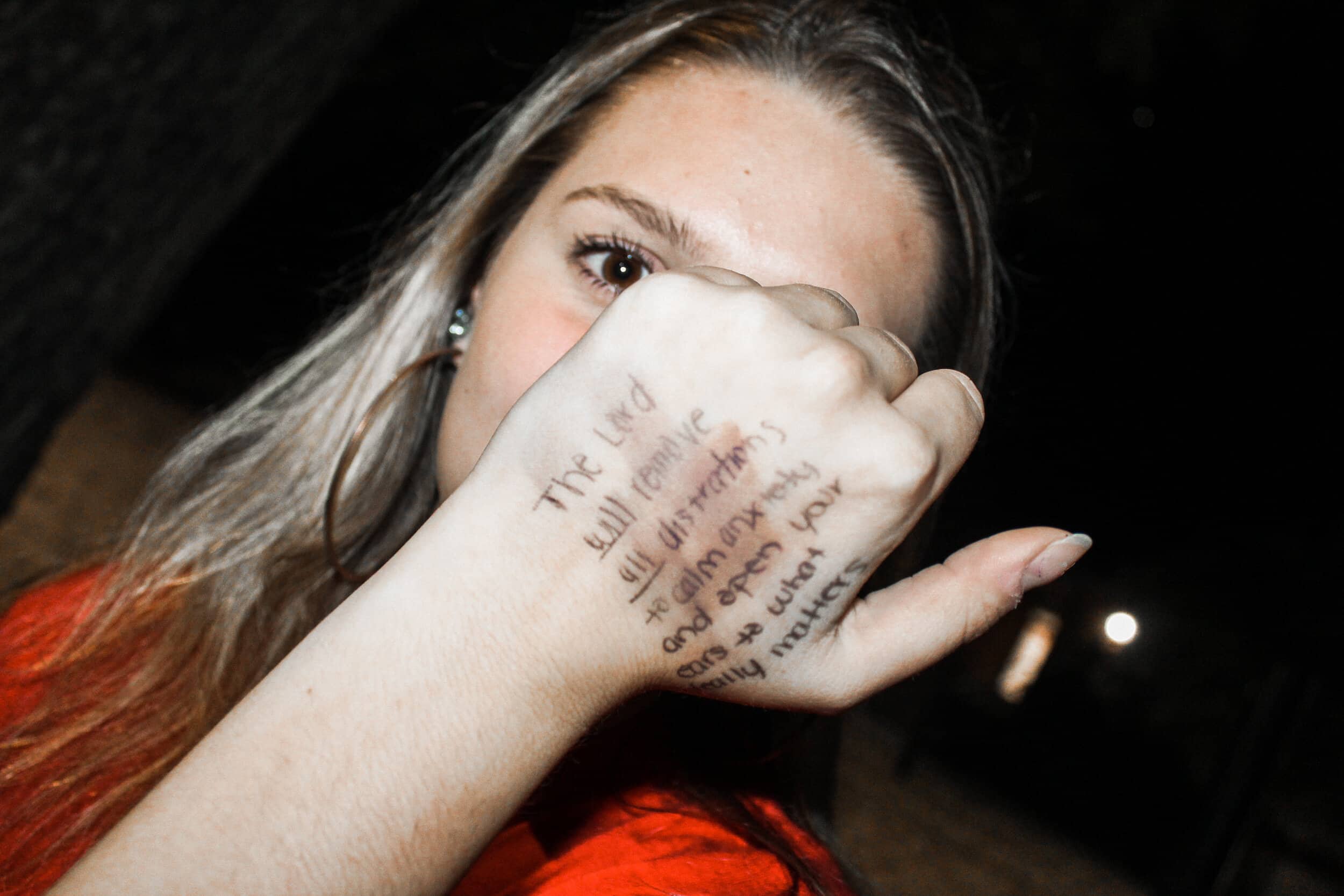 Freshman Maddie Barber showing a Bible verse from BCM on her hand.